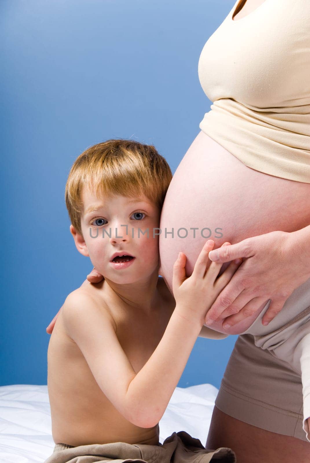 cute blond boy listening to the unborn child