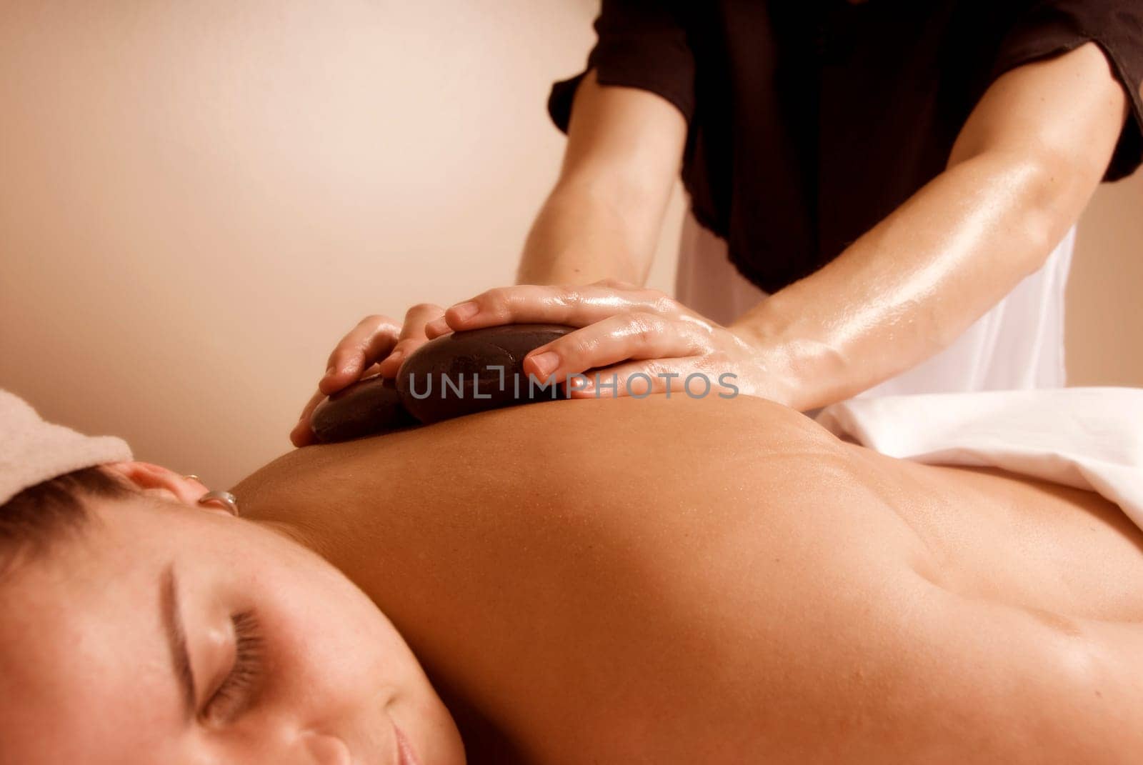 woman in a day spa getting a stone massage