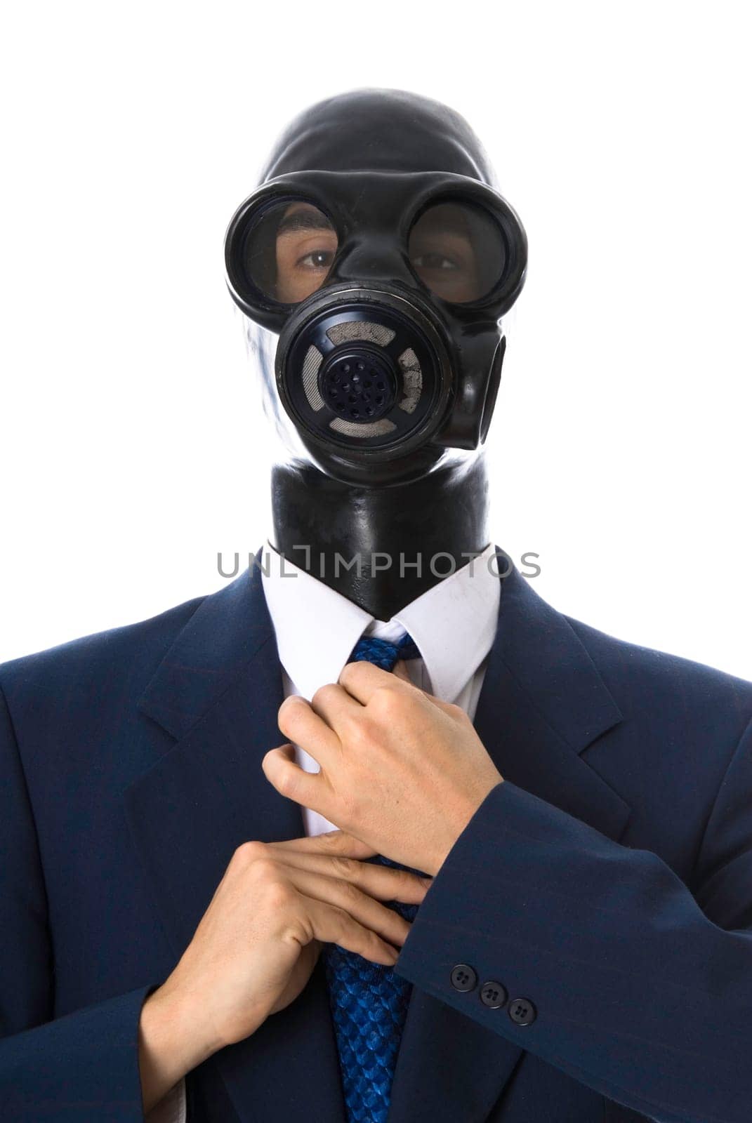 man in a blue suit with a latex mask fixing his tie