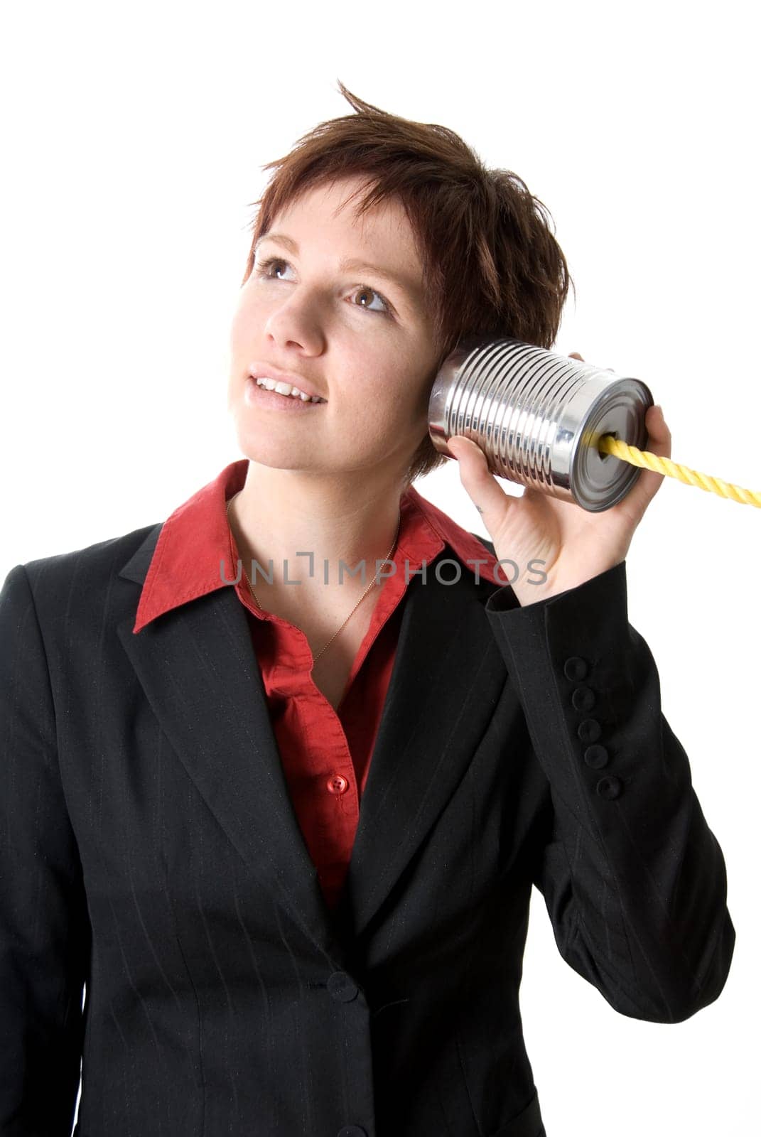 woman in a suit listening to a tin can phone