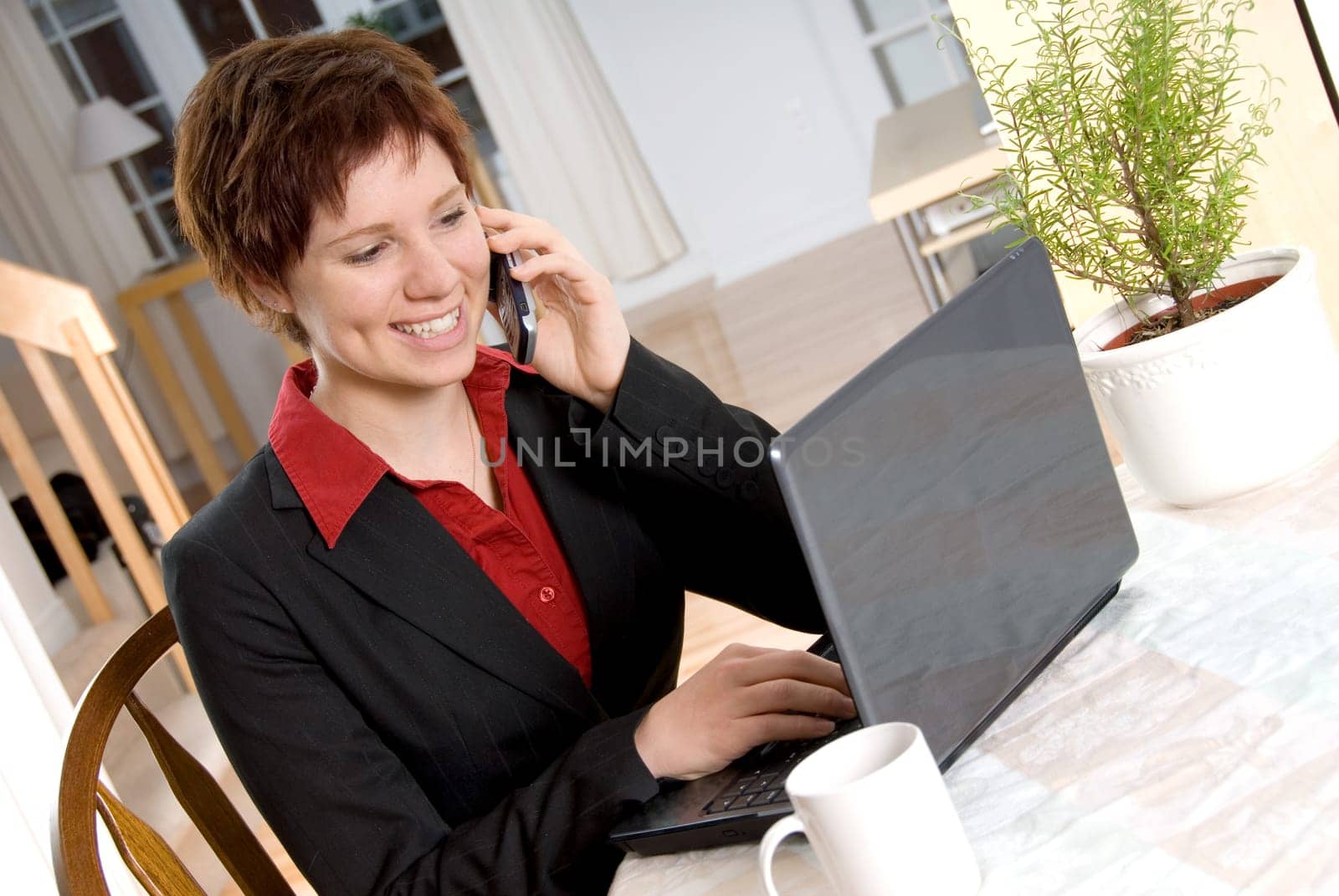 woman in a suit on the cell phone with laptop