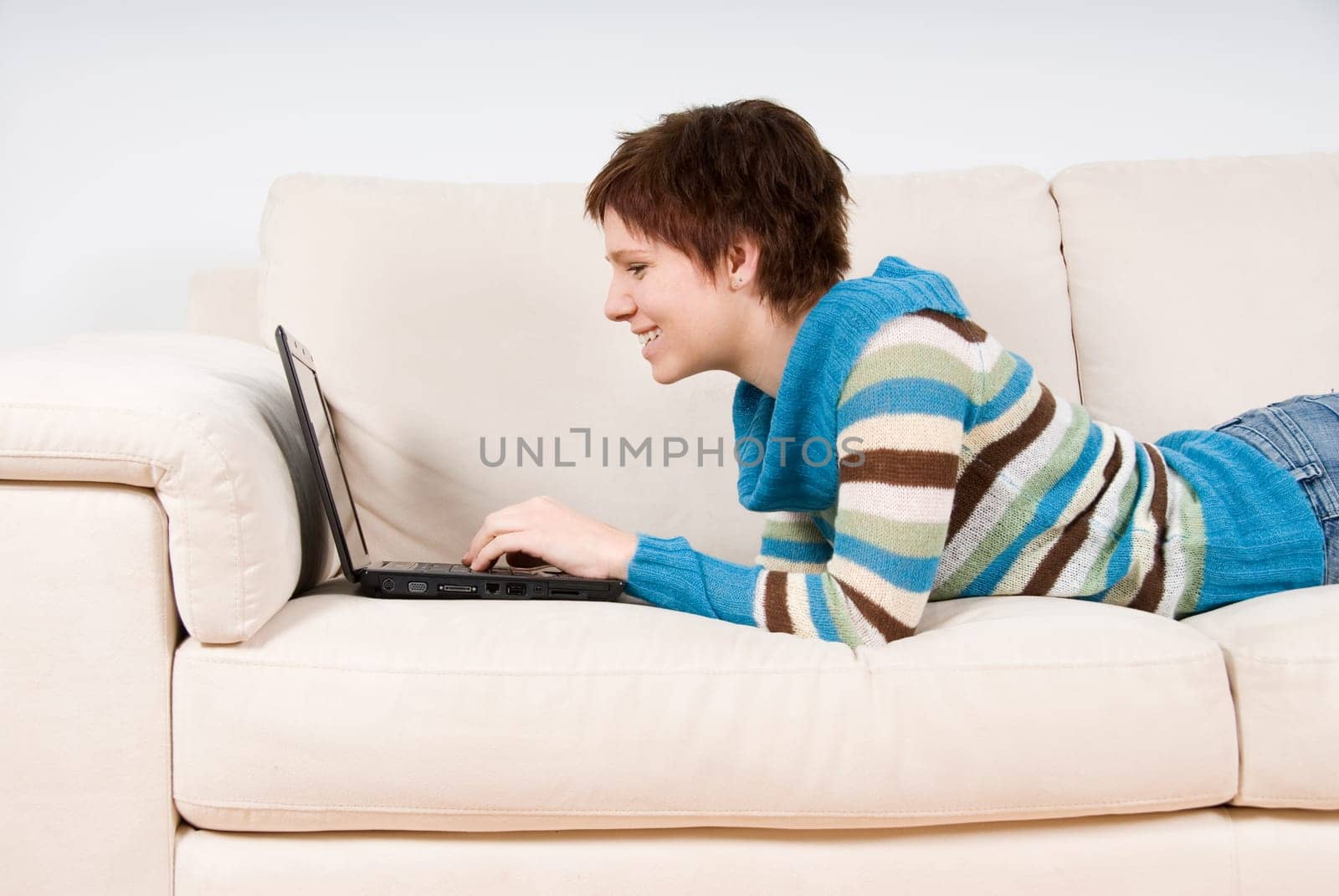 cute woman on her couch with her laptop