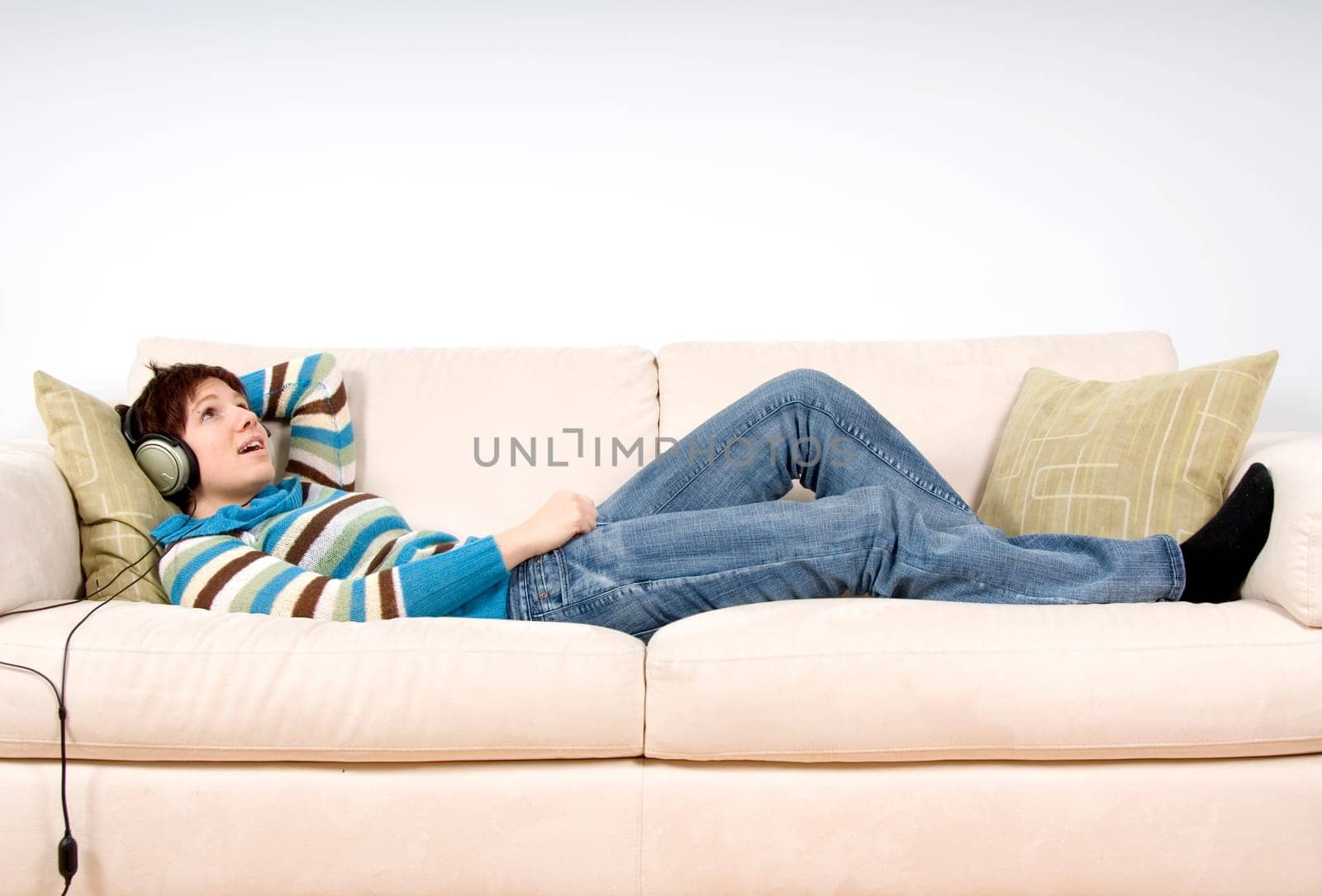 cute woman lying on the sofa with headphones