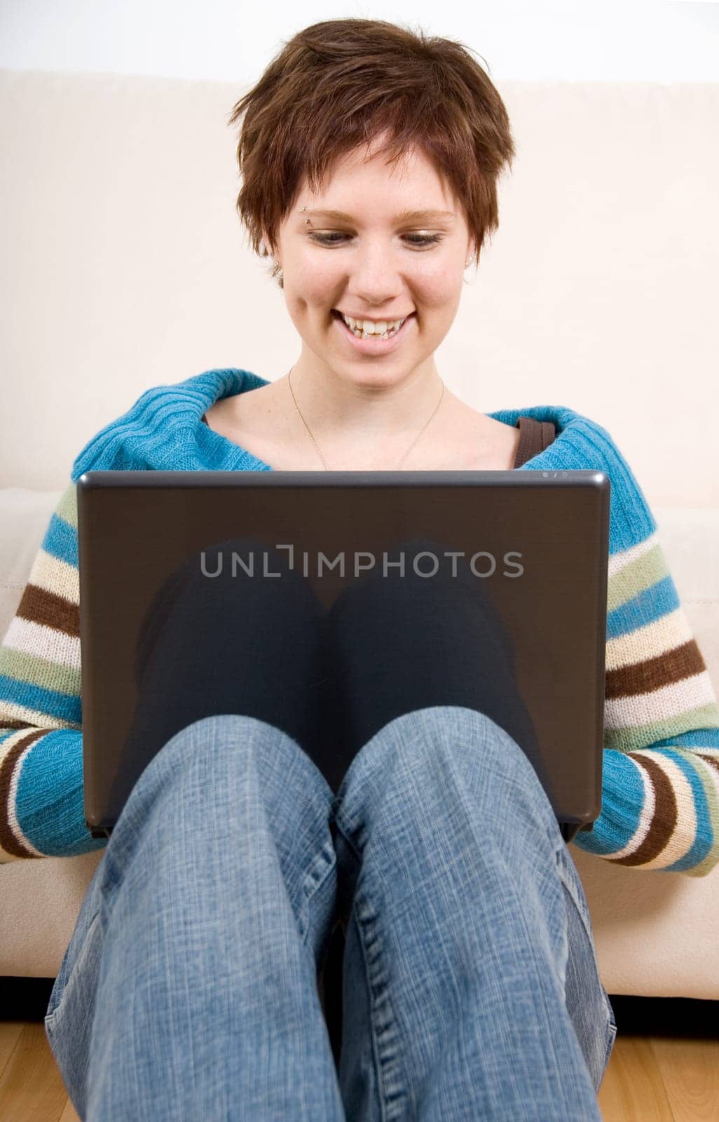 cute girl with her laptop back against the couch