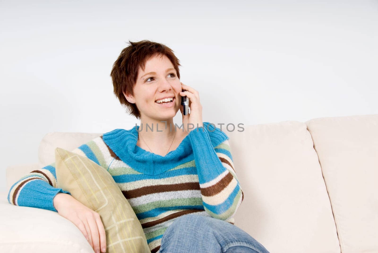 cute girl sitting on the couch with phone