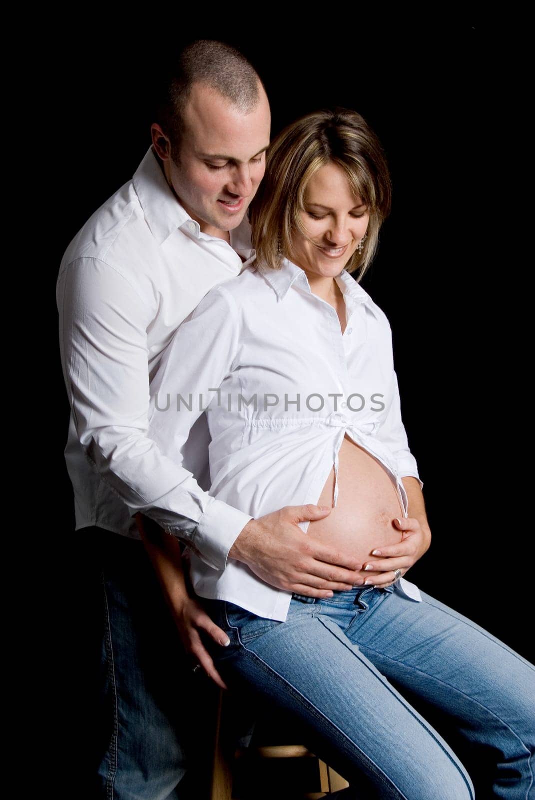 pregnant woman and her boyfriend on black background