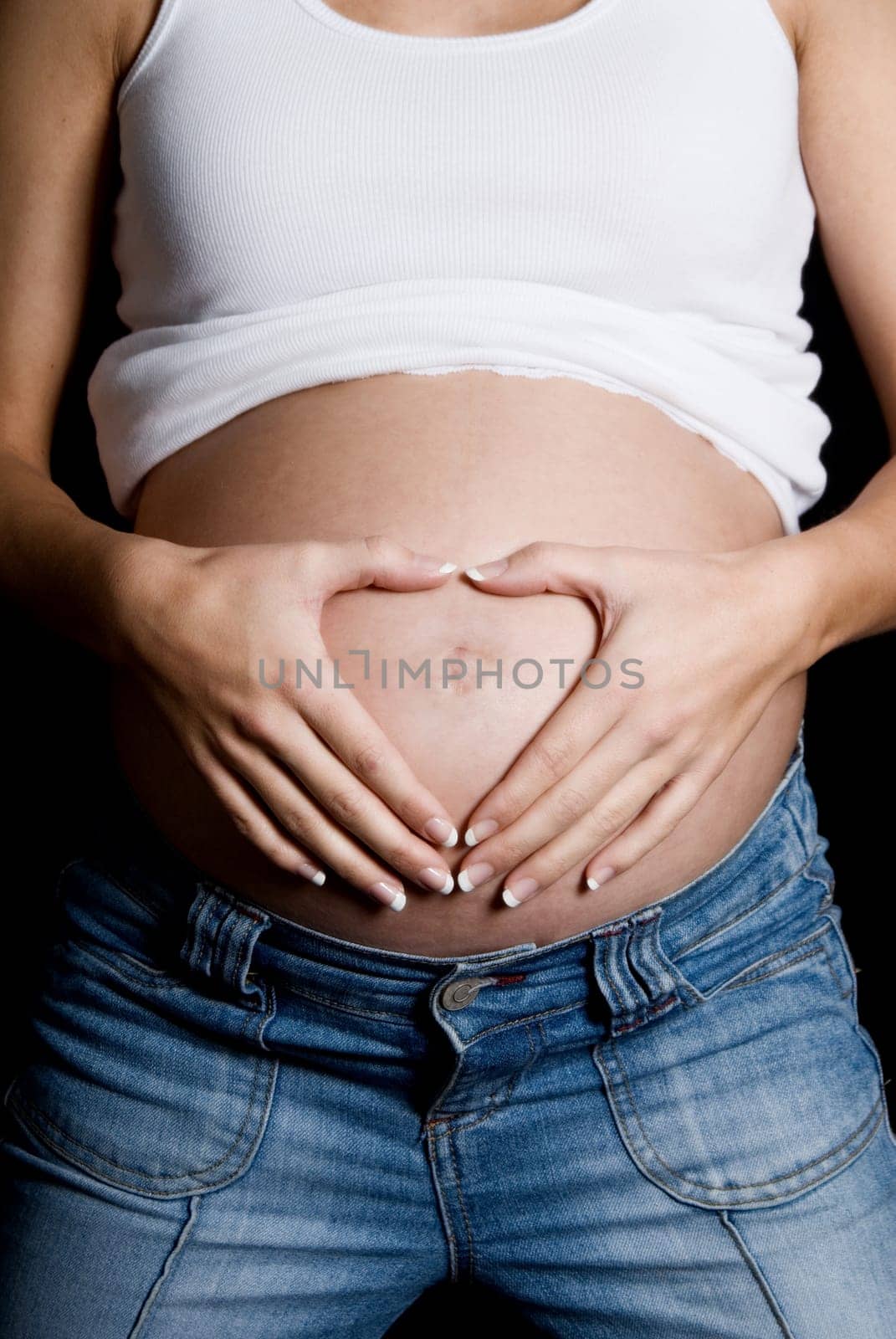 pregnant woman doing a heart shape with hands