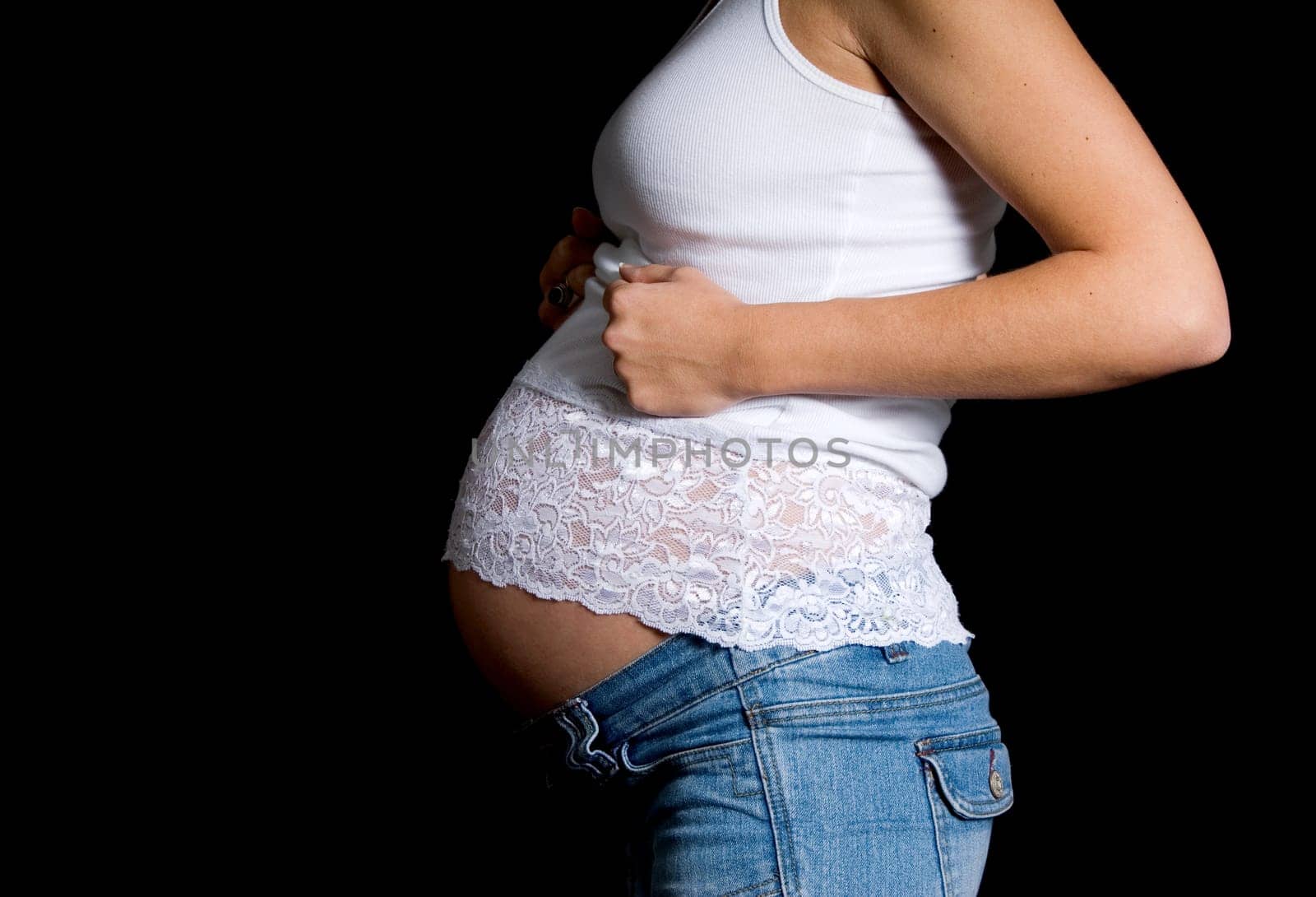 pregnant belly with white lace top on black