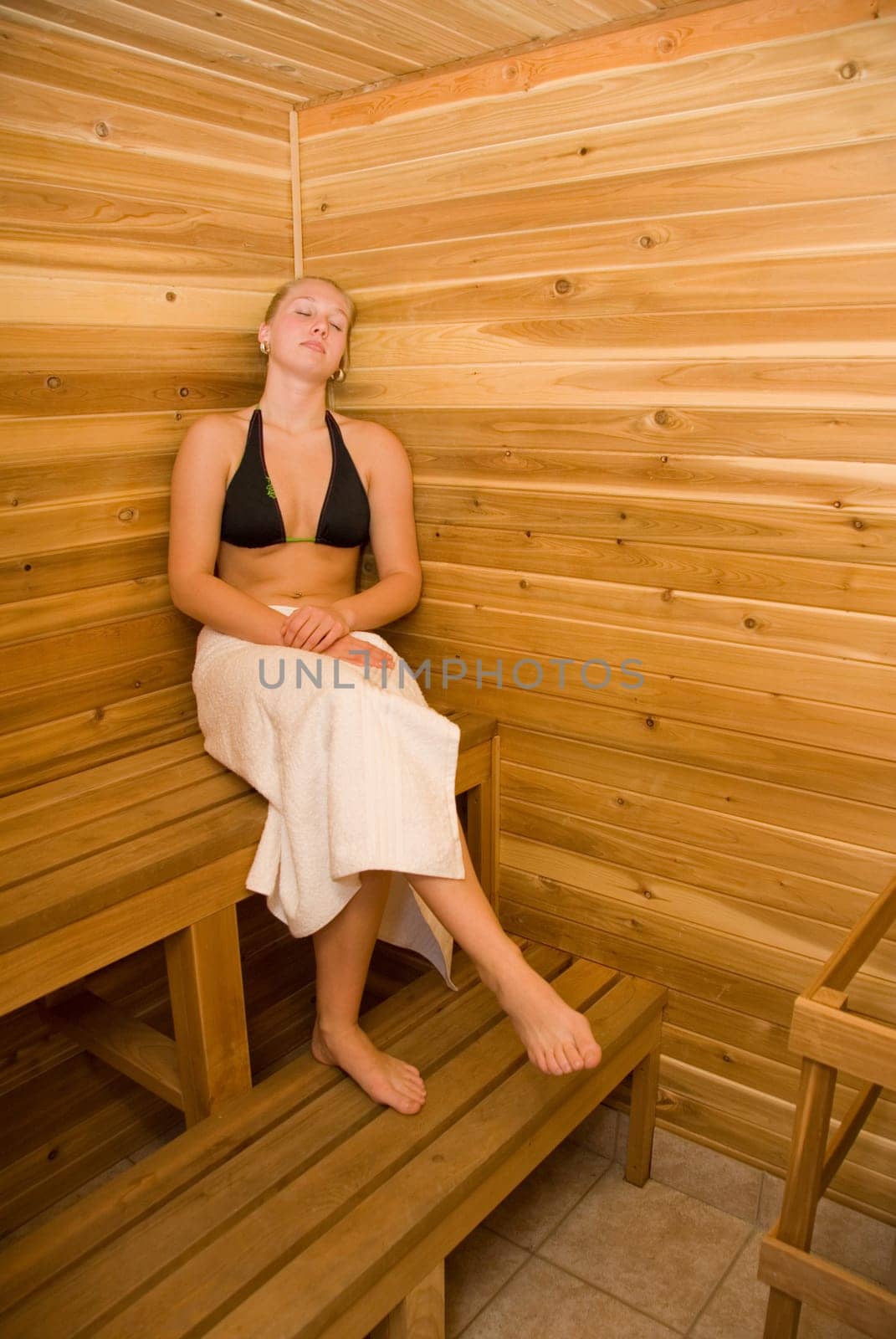 cute woman relaxing in the wood sauna