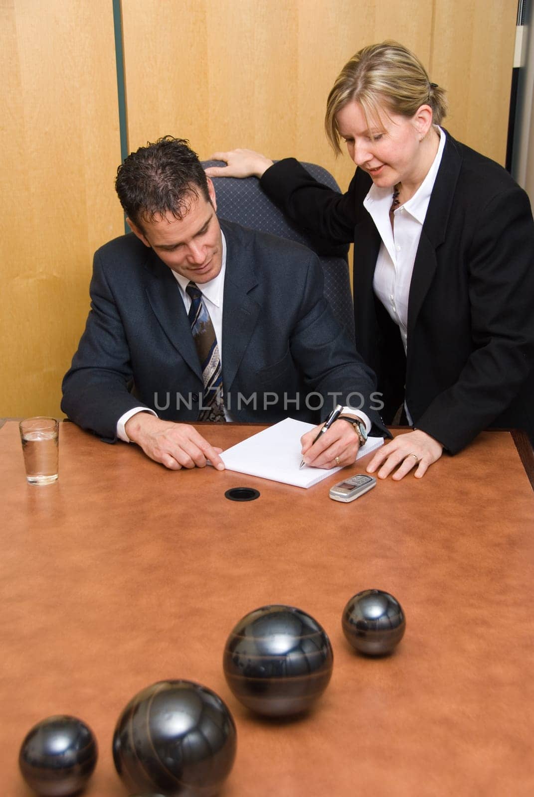 man and woman in a room with a laptop taking notes