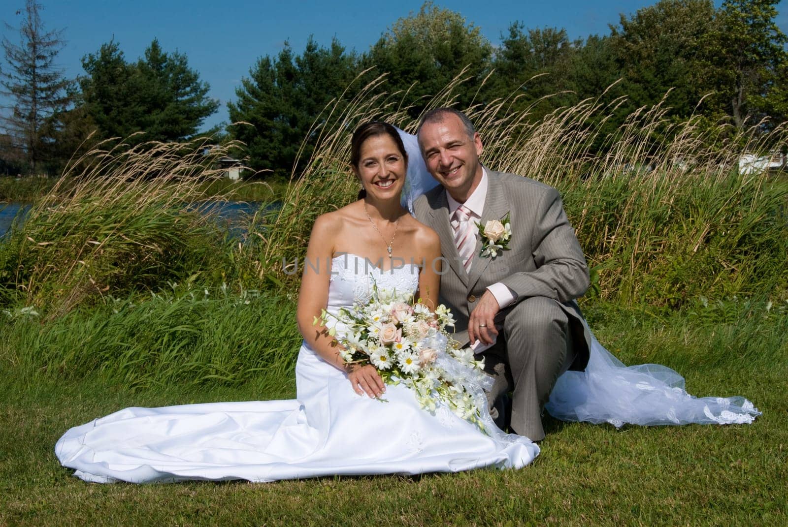 a just married man and woman by a lake