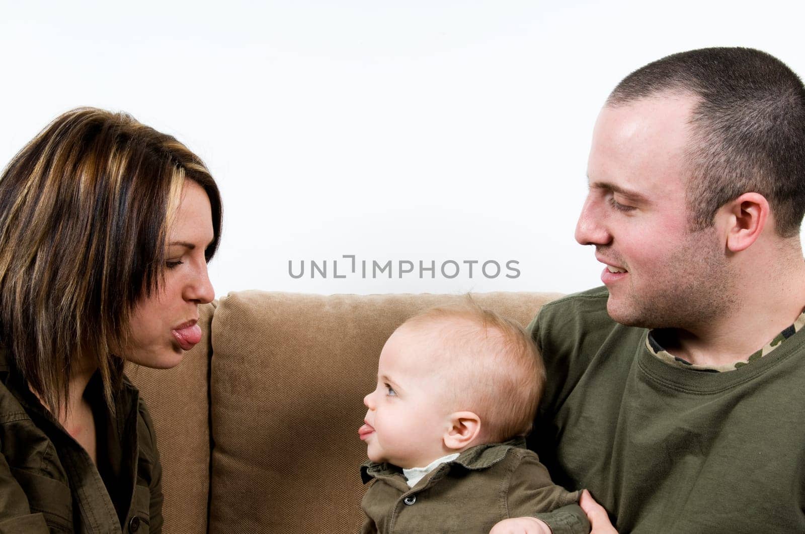 mom and dad on a sofa with their baby boy