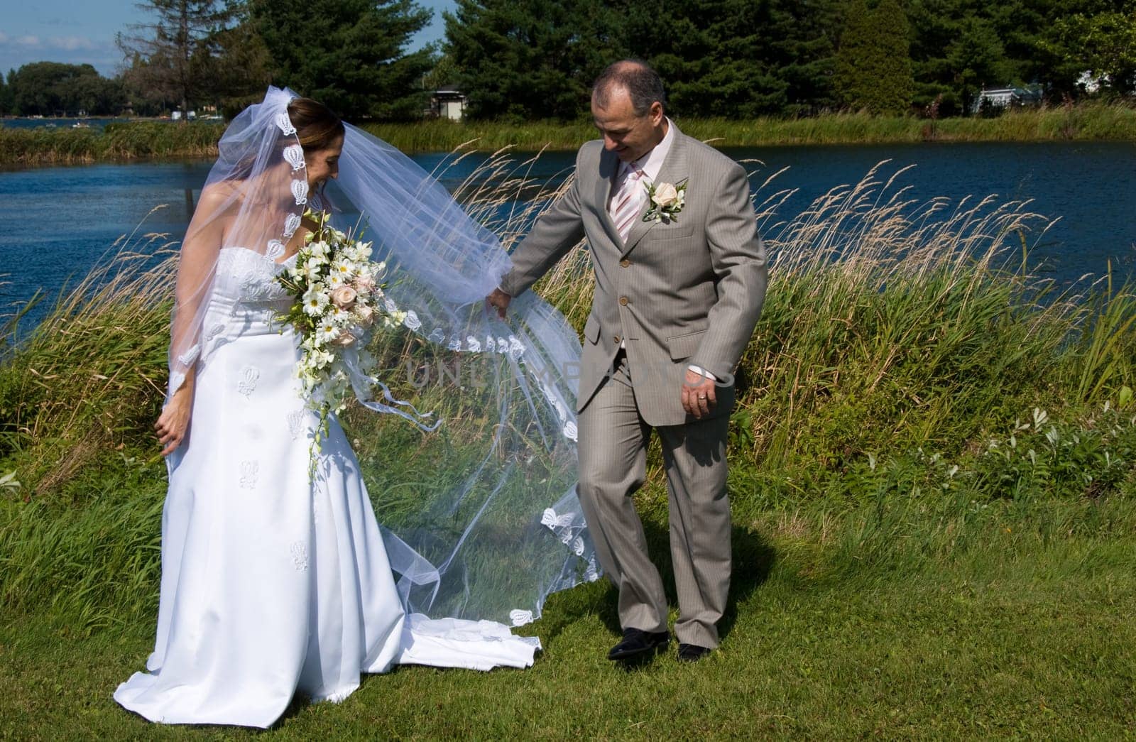 a just married man and woman by a lake