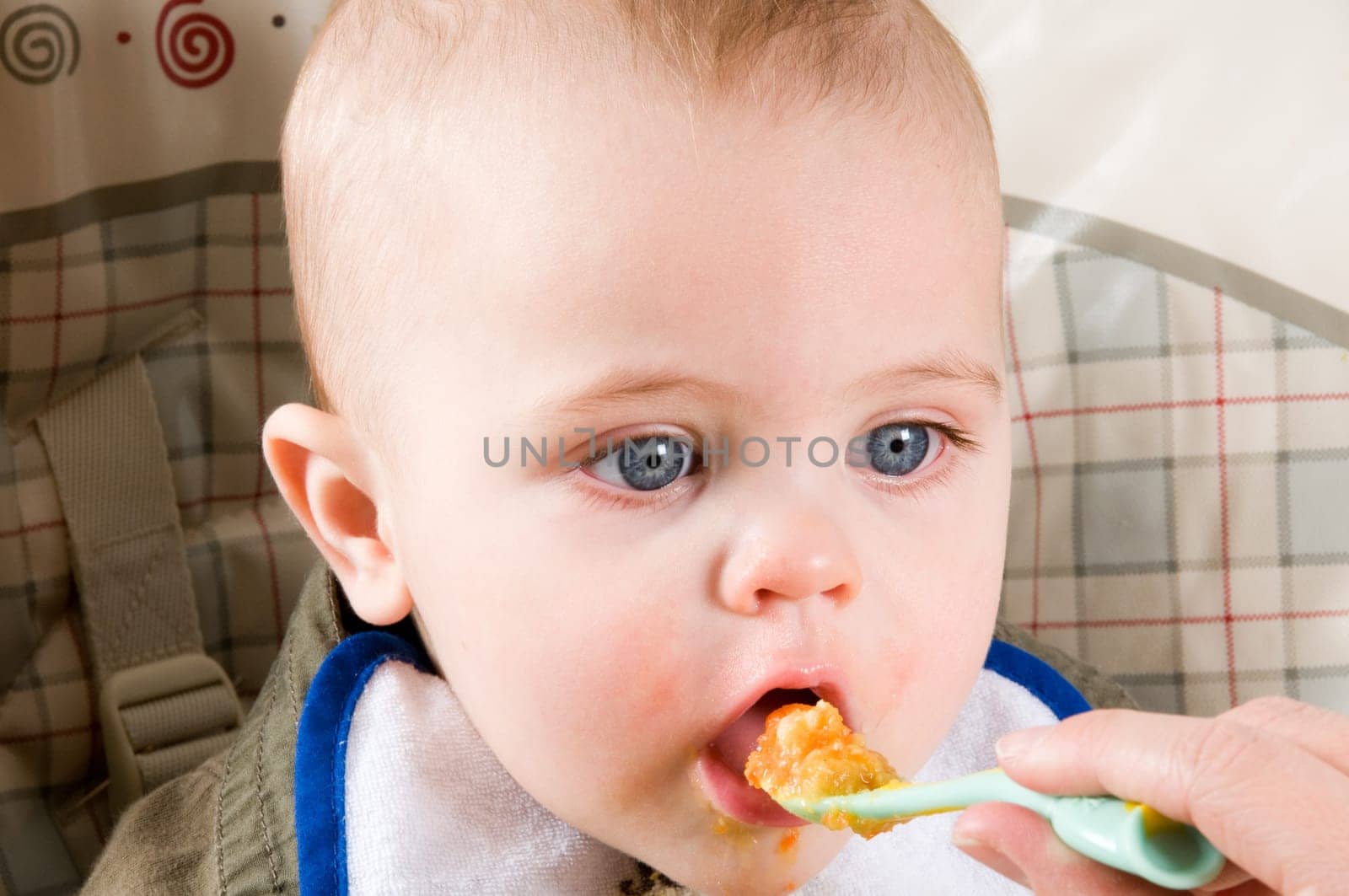 parent feeding a cute baby healthy food