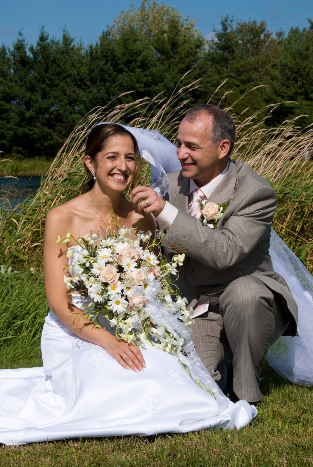 a just married man and woman by a lake