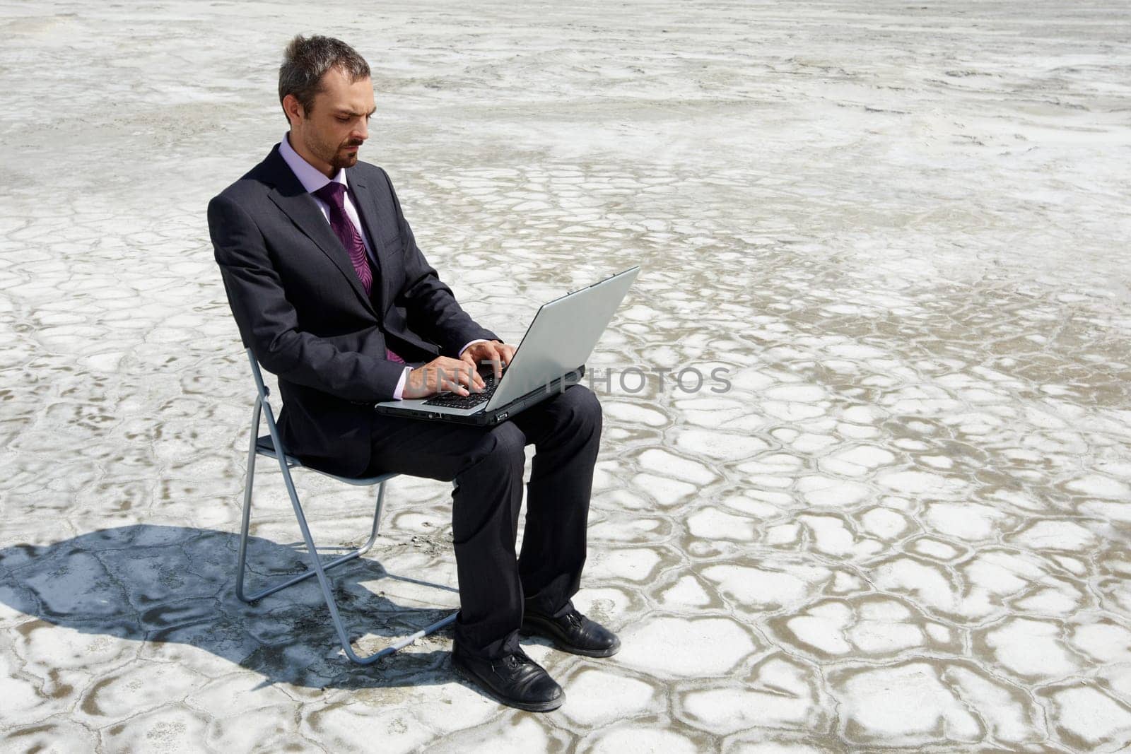 Photo of modern businessman typing on laptop outside