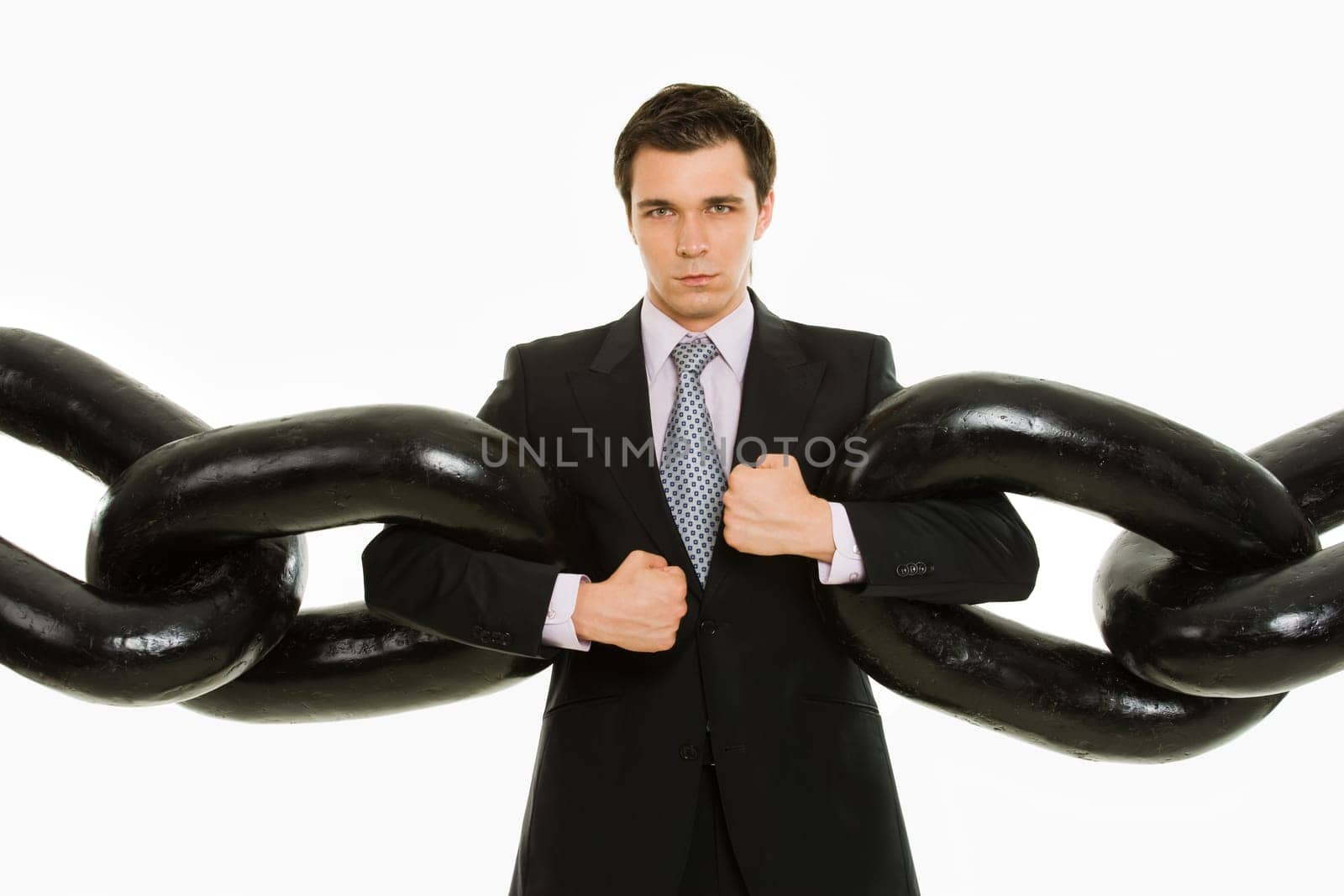 Portrait of powerful businessman with several sections of huge chain over white background