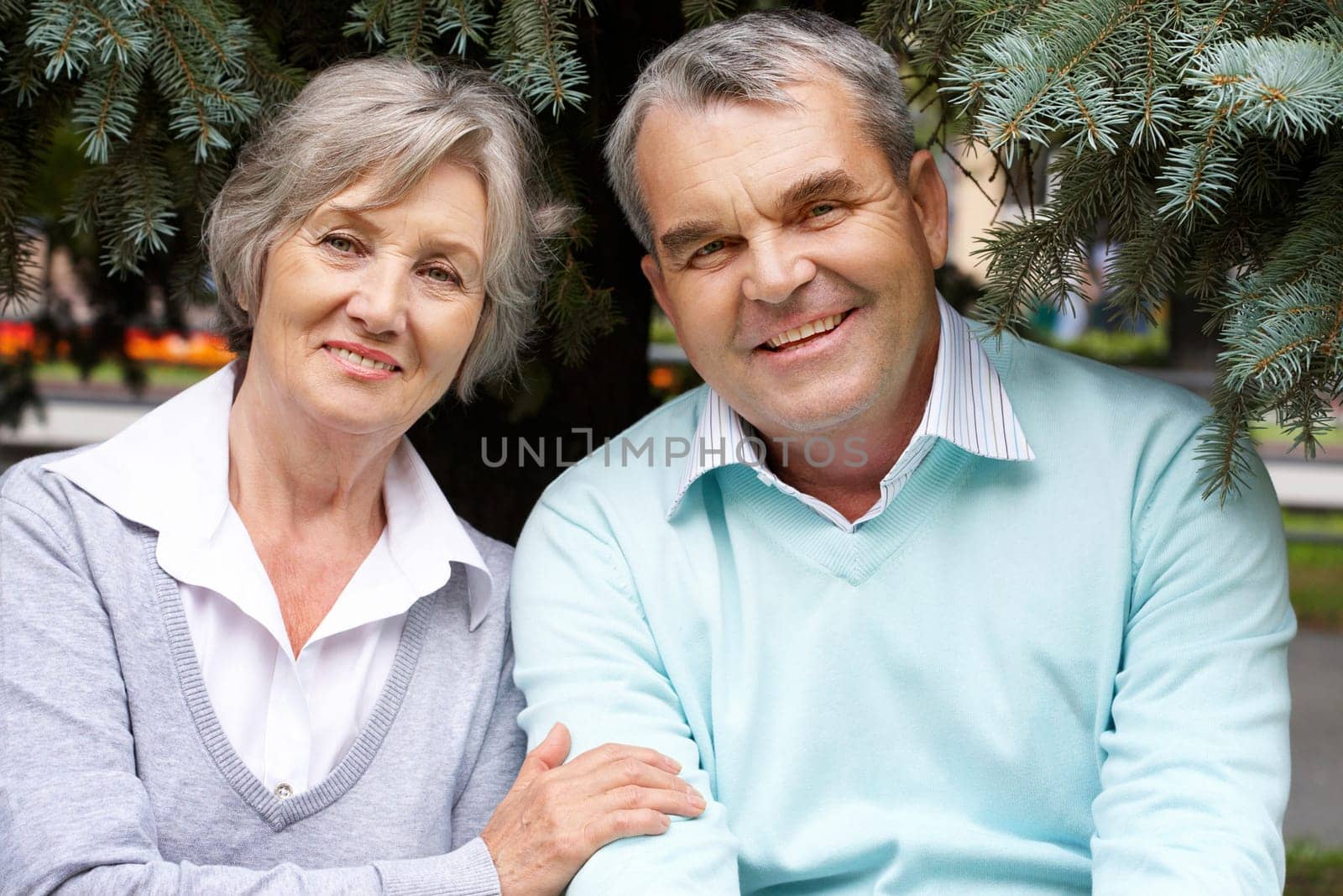 Portrait of happy senior couple looking at camera outdoors