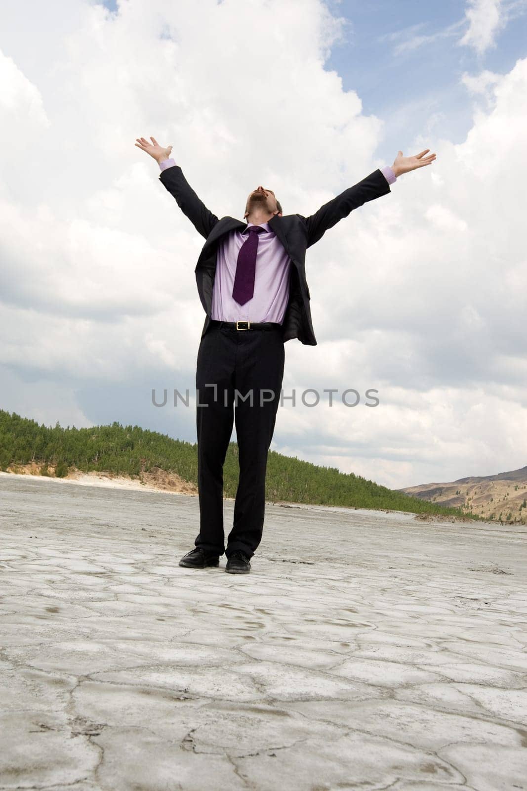 Photo of elegant businessman standing and raising his arms outdoors in summer