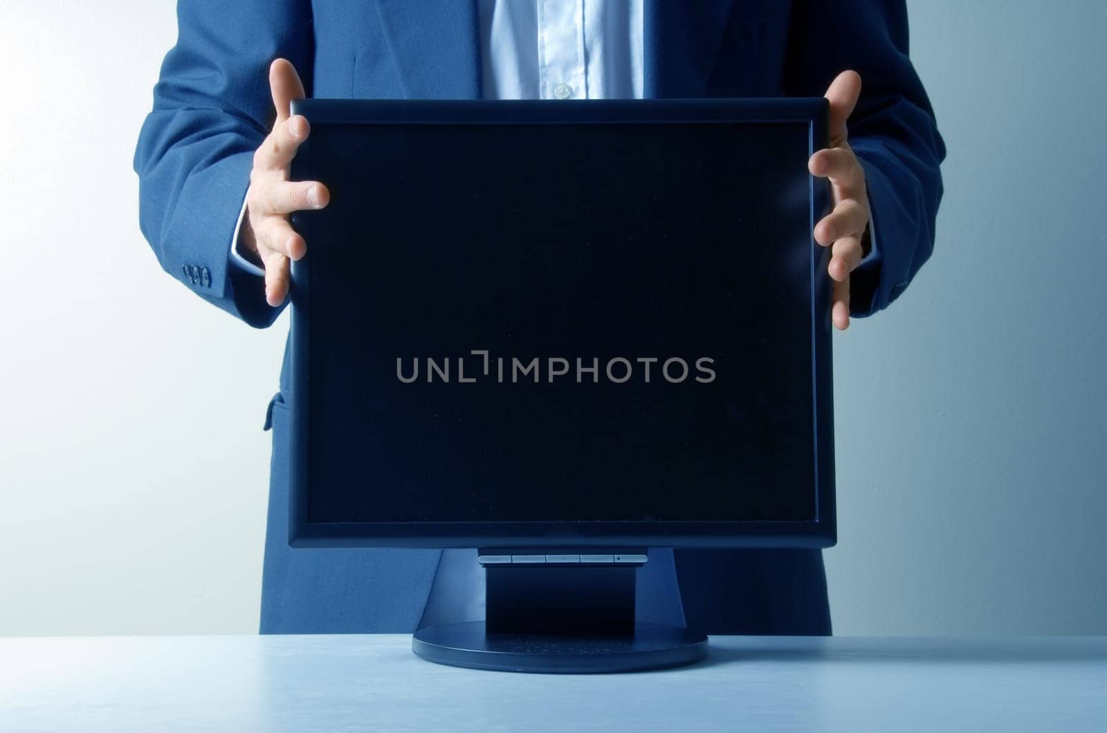 businessman holding an lcd monitor