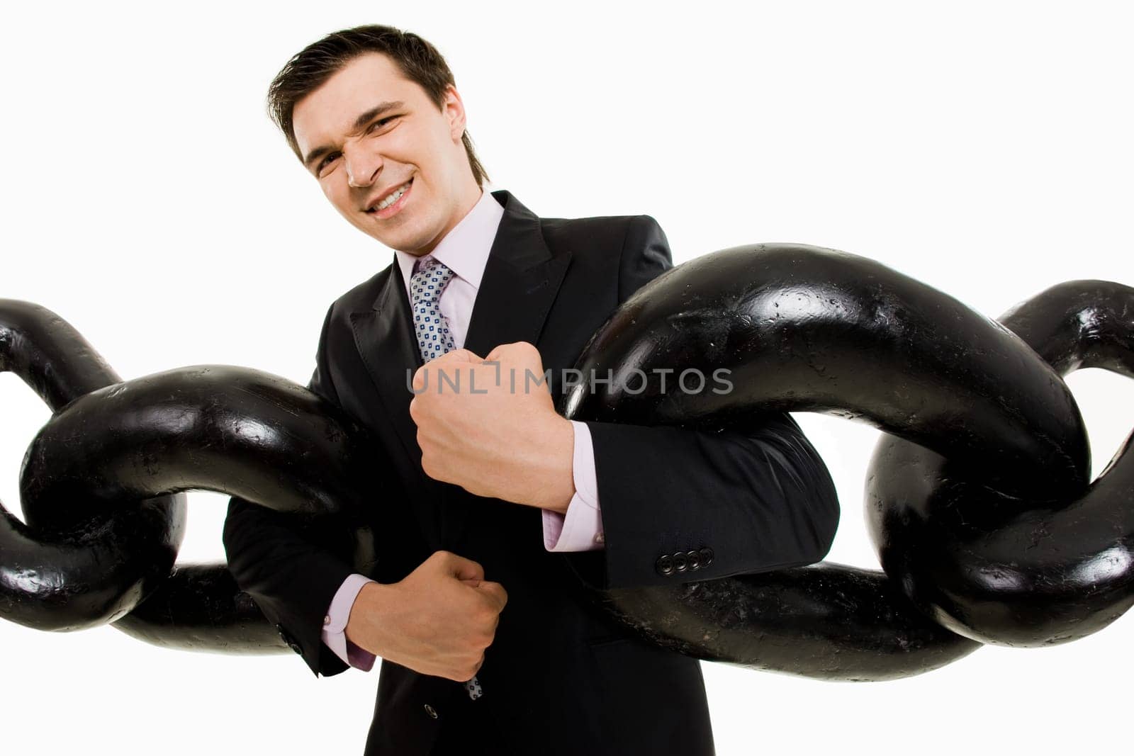 Portrait of powerful businessman with two sections of huge chain looking at camera tensely
