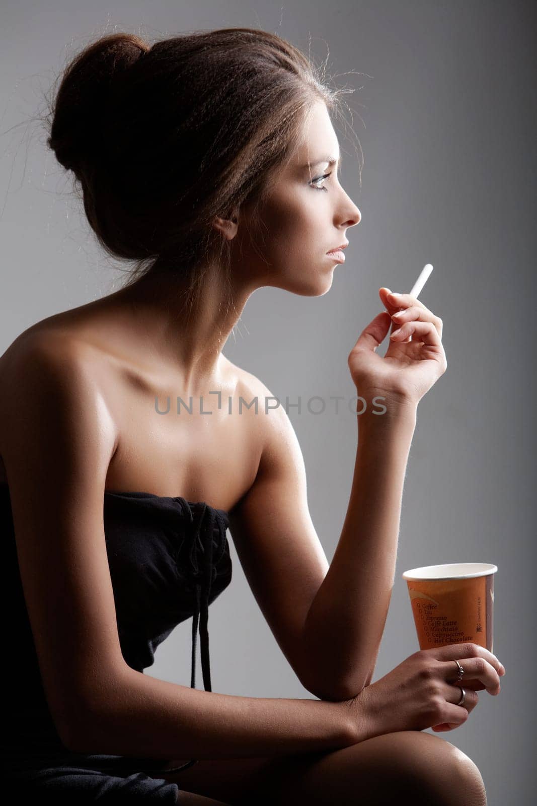 Portrait of elegant female smoking with plastic glass in hand