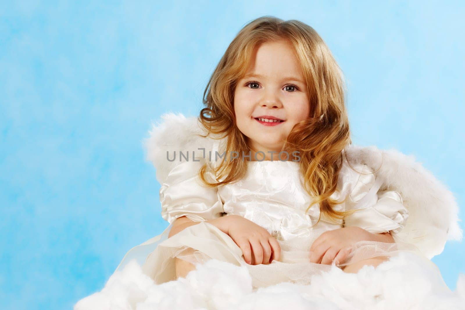 Happy little girl with smile wearing angel dress