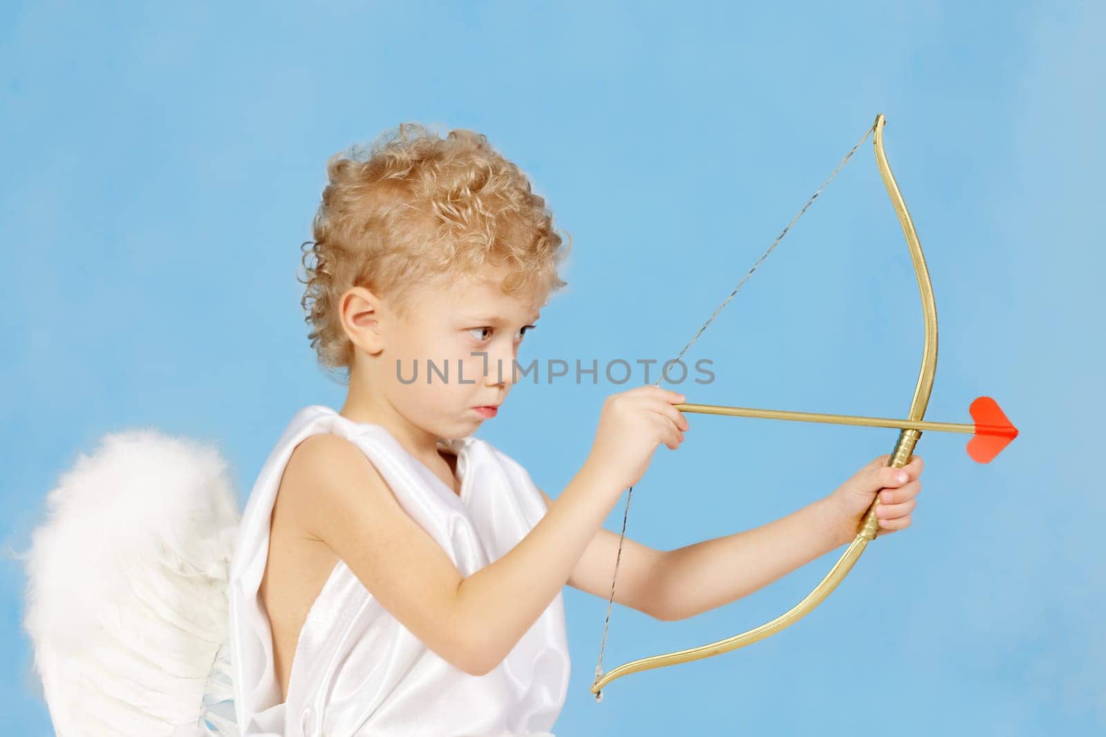 Portrait of little boy with bow and arrow ready to make someone fall in love