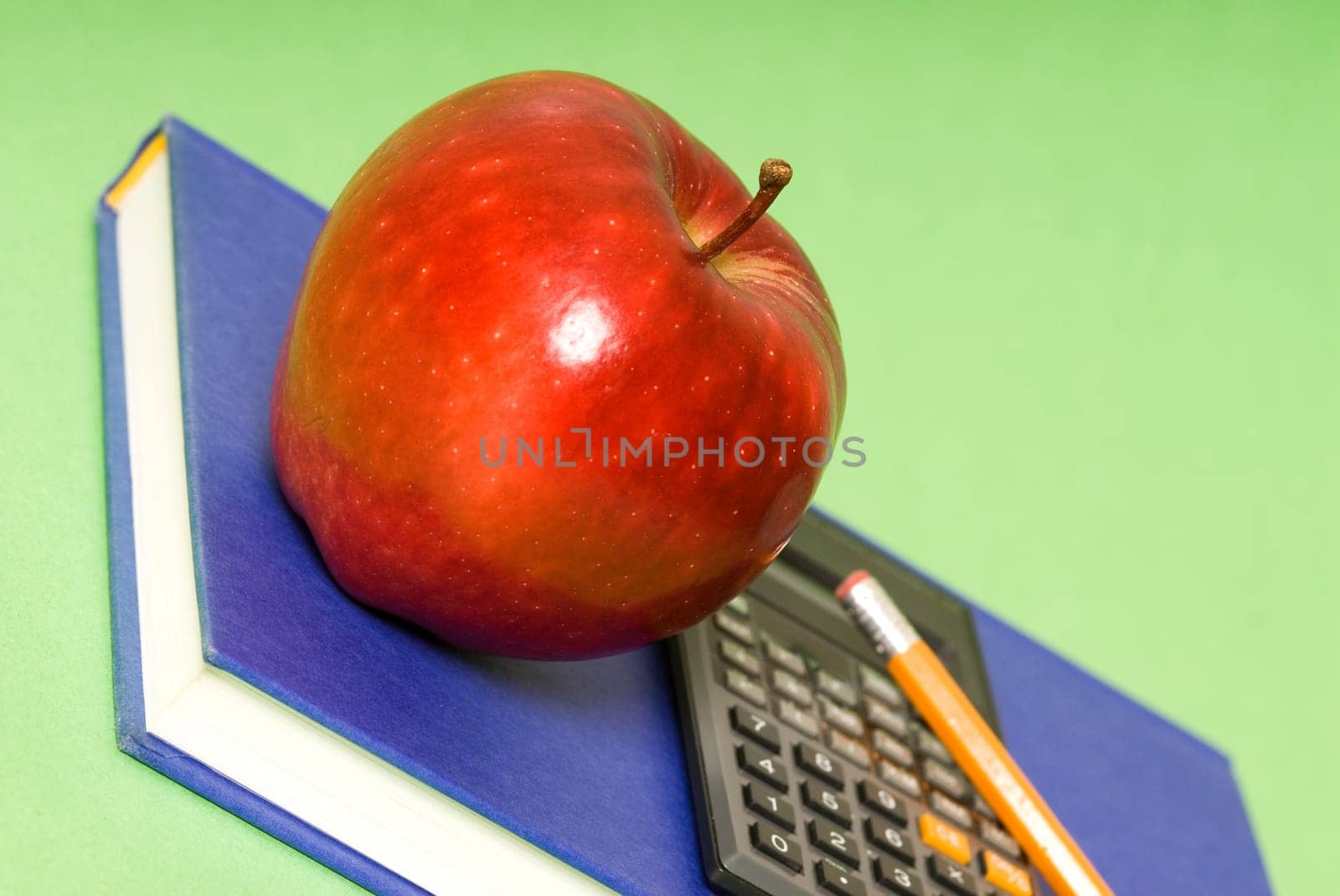 red apple and blue book and black calculator