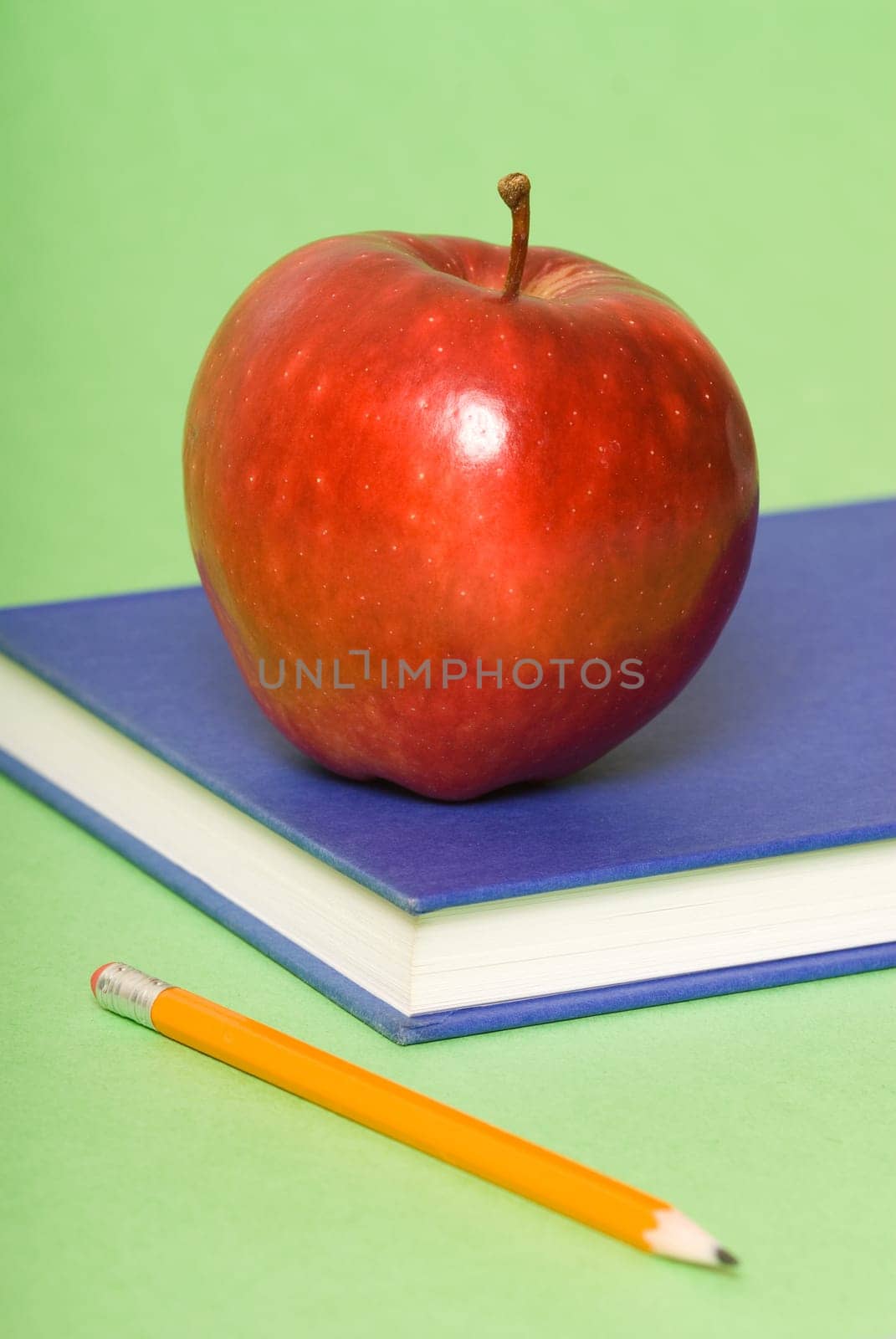 blue book with red apple and pencil