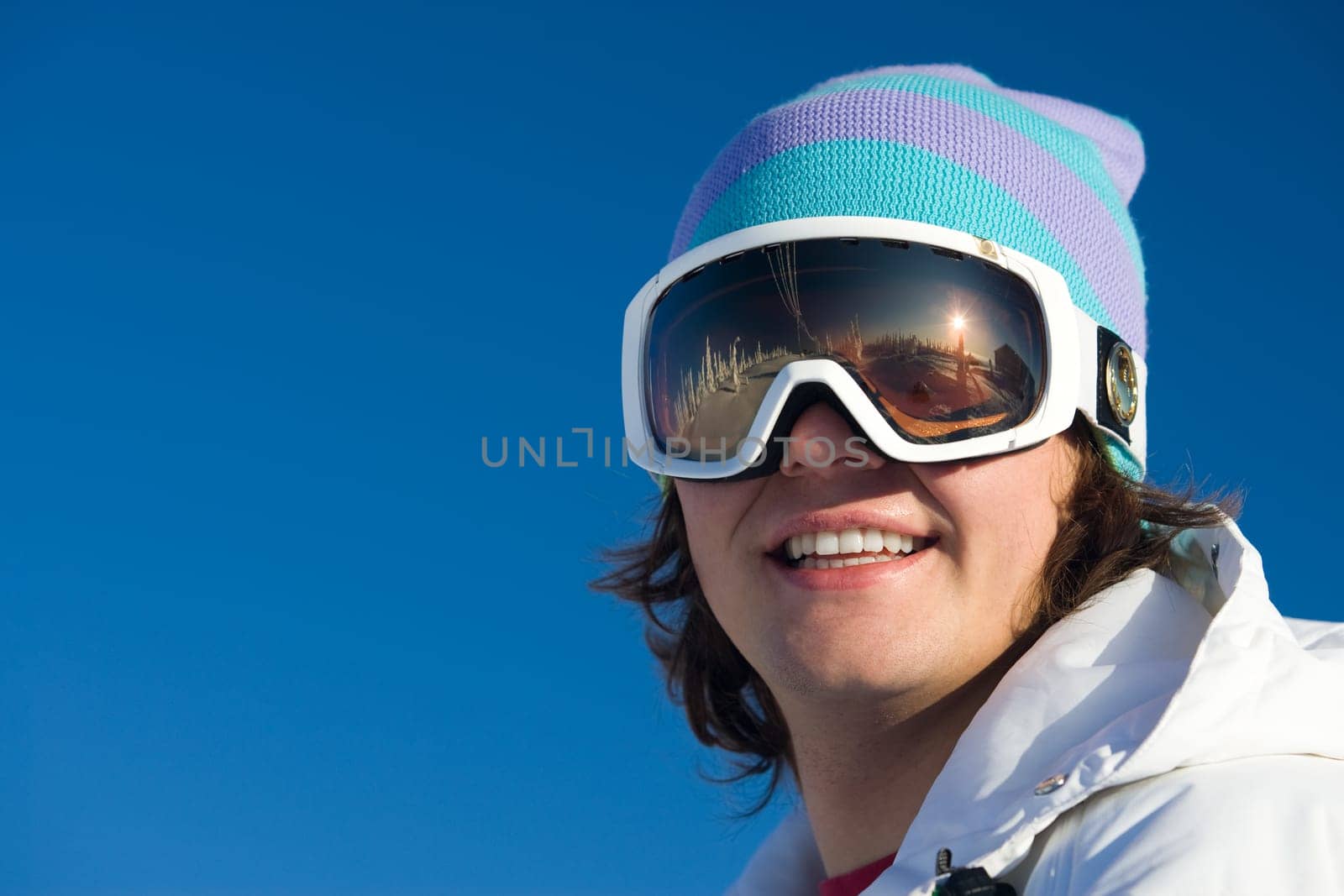 Portrait of happy young man looking at camera through eyeglasses and smiling