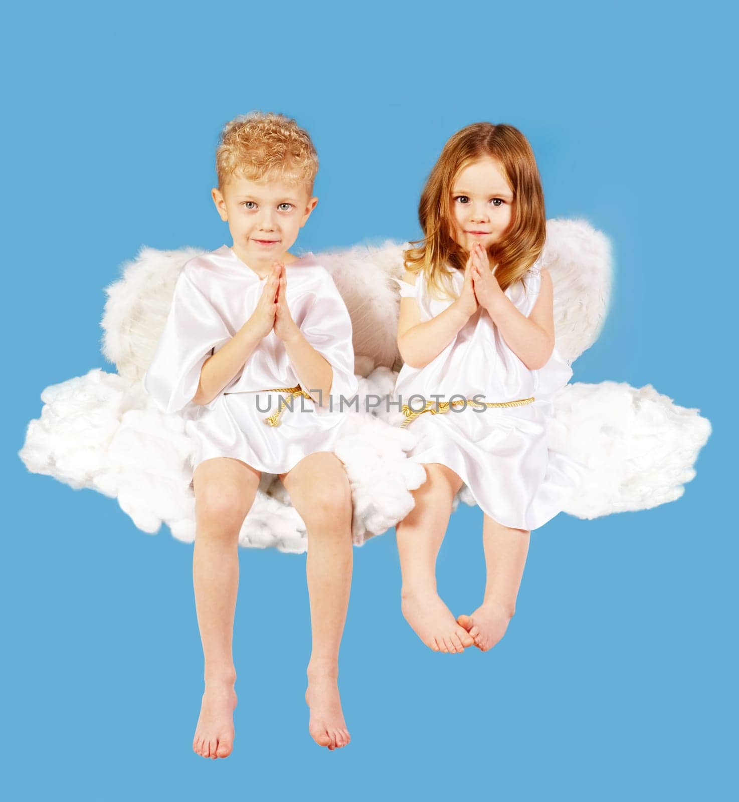 Portrait of two cute angels sitting on the cloud