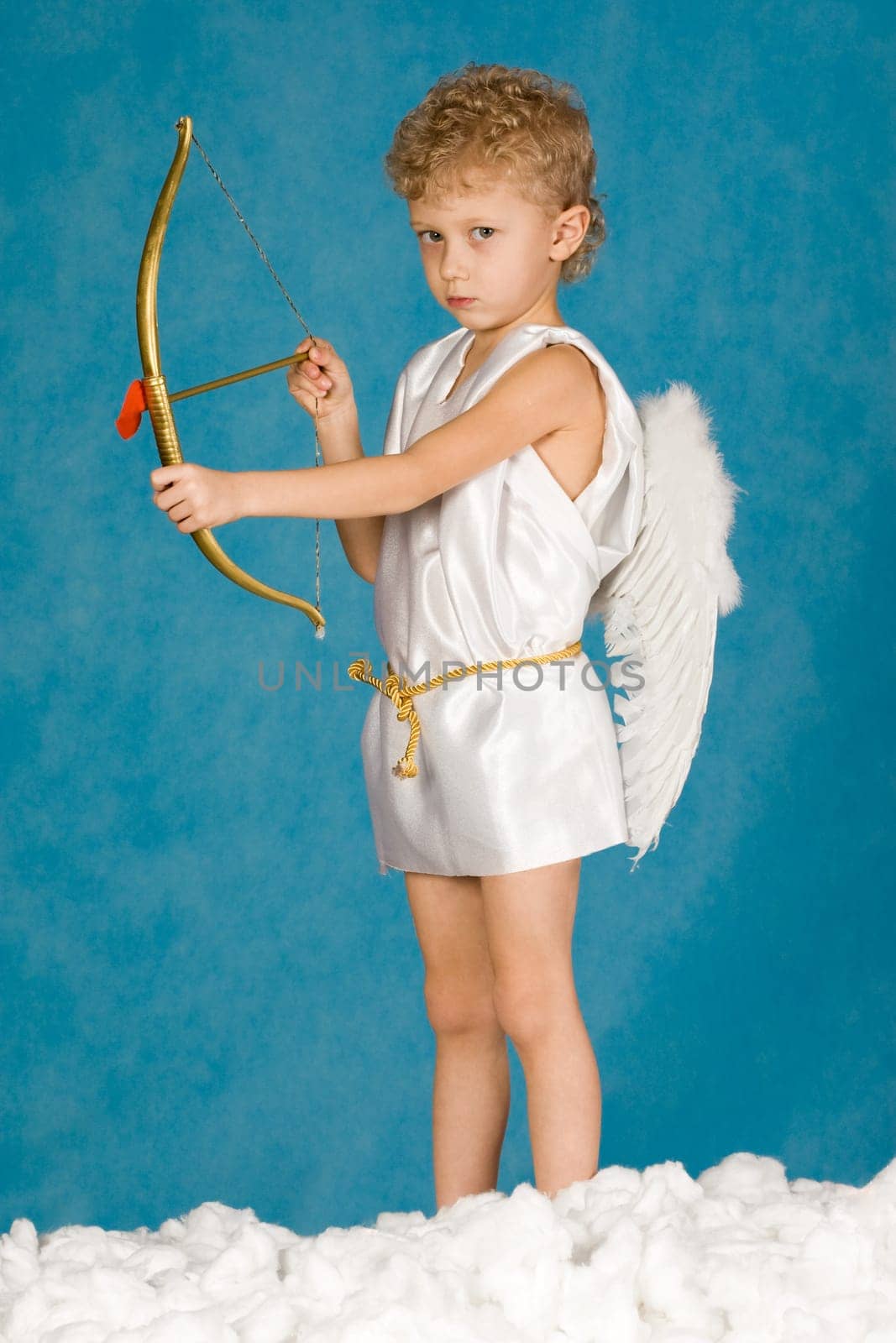 Portrait of young male angel holding bow