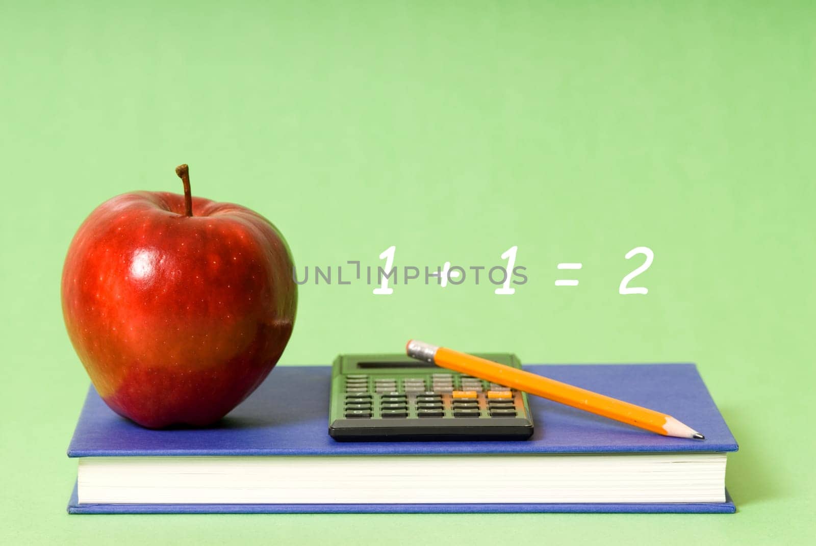 blue book and red apple and pencil and calculator