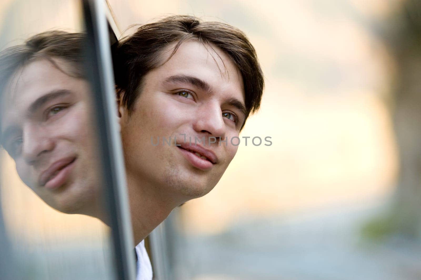 Photo of young commuter looking out of train window during journey