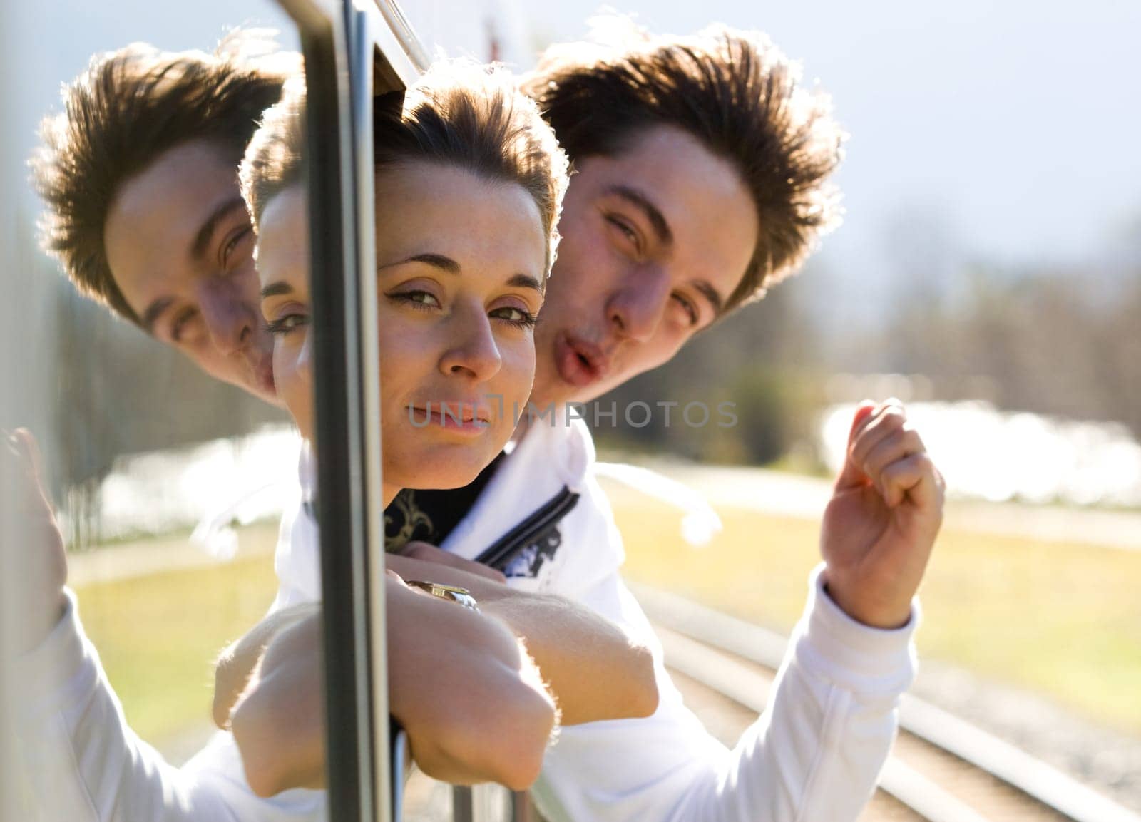 Photo of romantic couple looking out of train window and having fun
