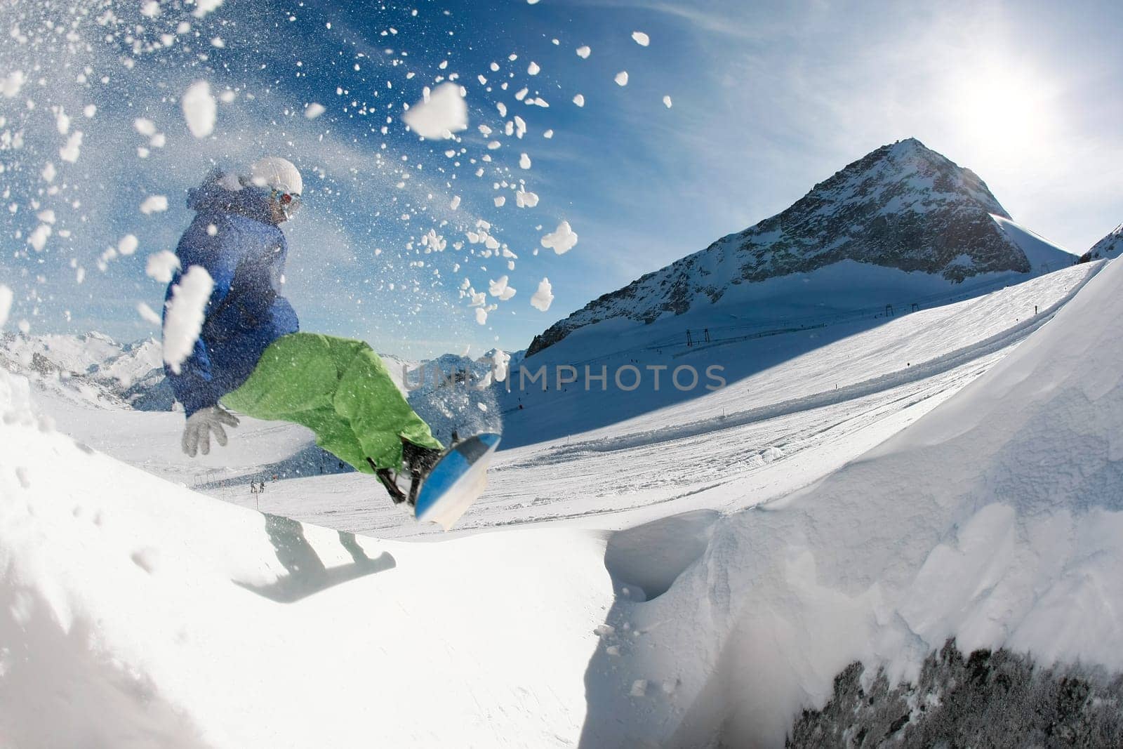 Photo of snowboarder over snowdrift going in for sport in winter
