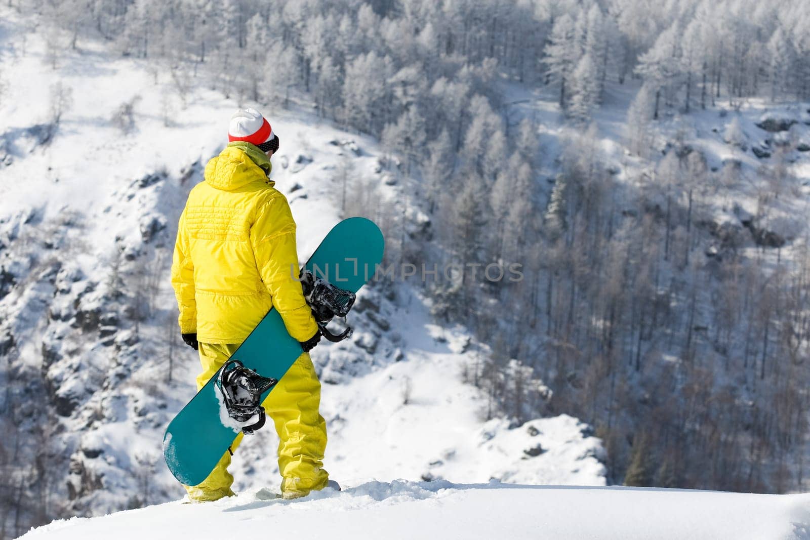 Rear view of snowboarder standing in snowdrift in winter