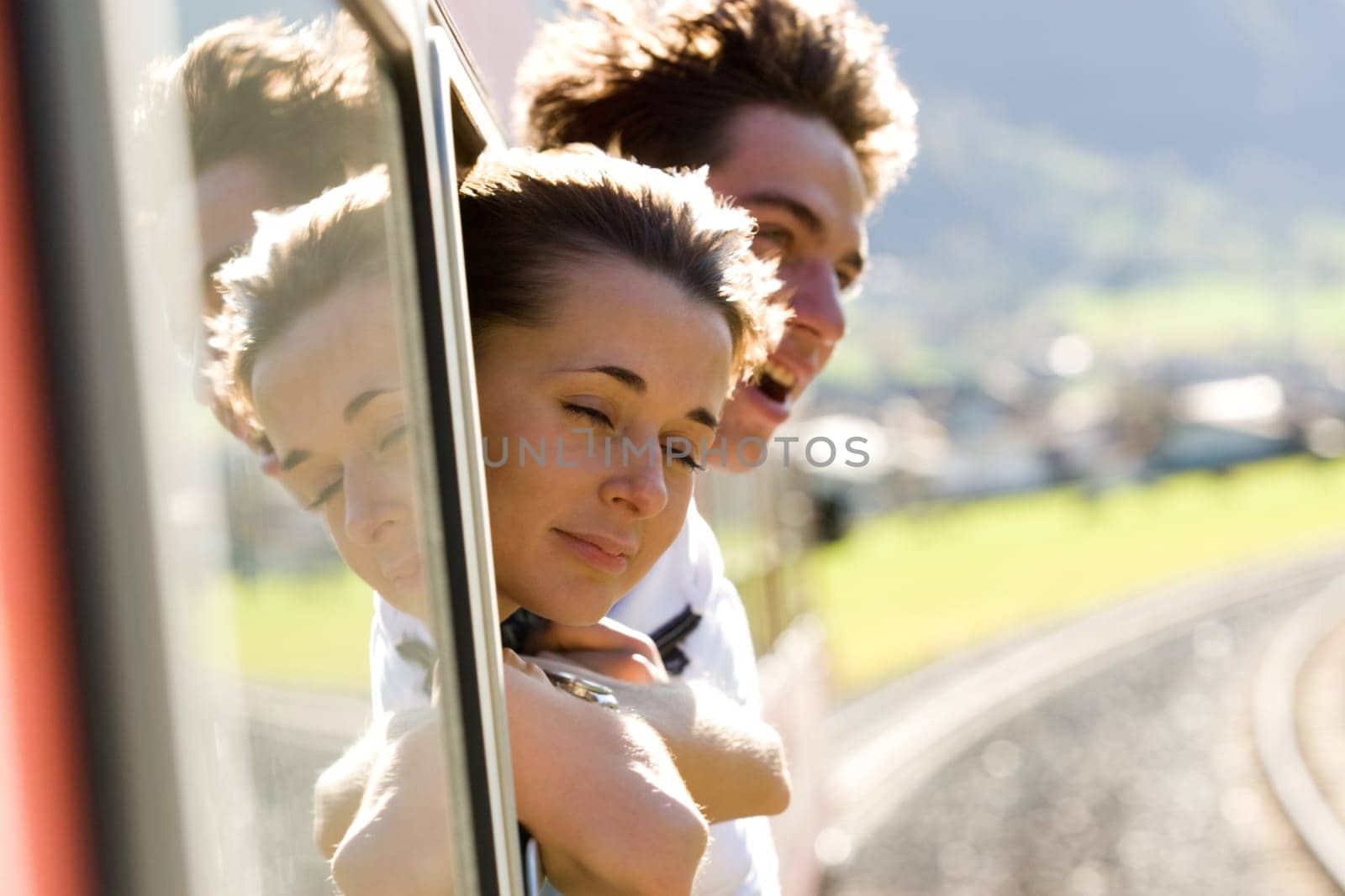Photo of romantic couple looking out of train window while their travel