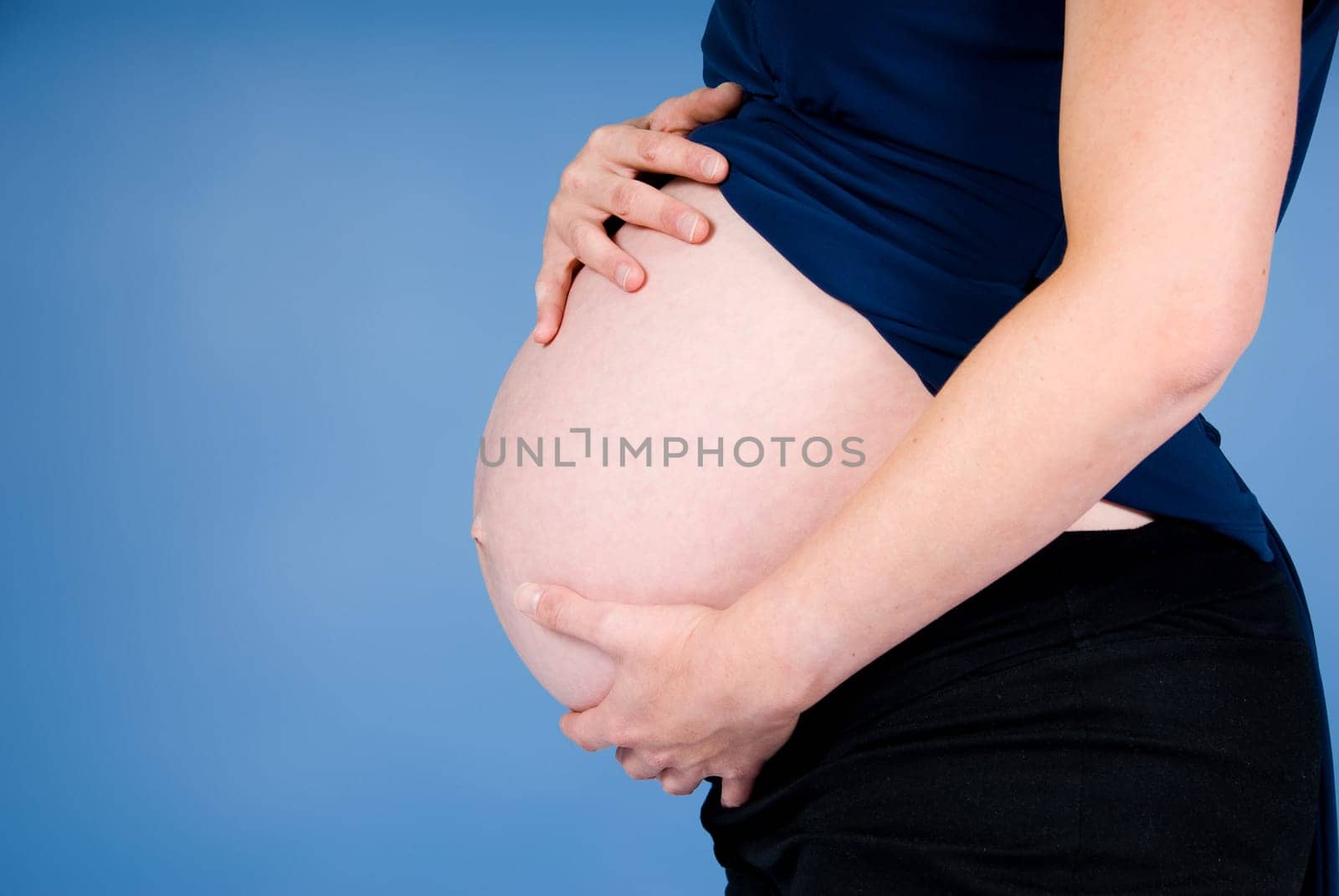 very pregnant woman showing her big belly
