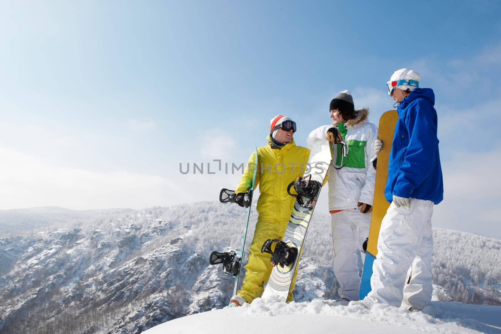 Portrait of handsome snowboarders standing on the mountain