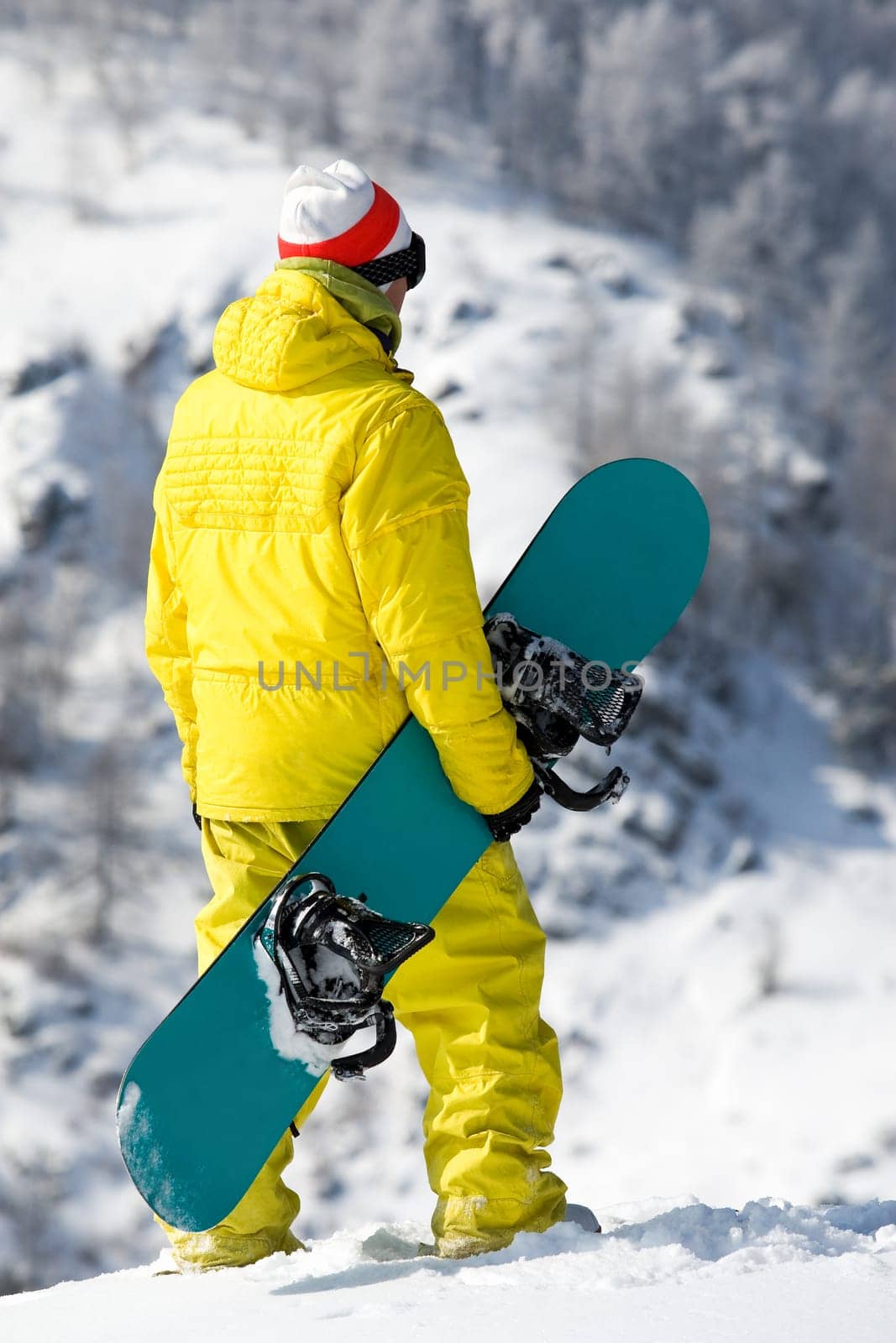 Rear view of snowboarder standing in snowdrift in winter