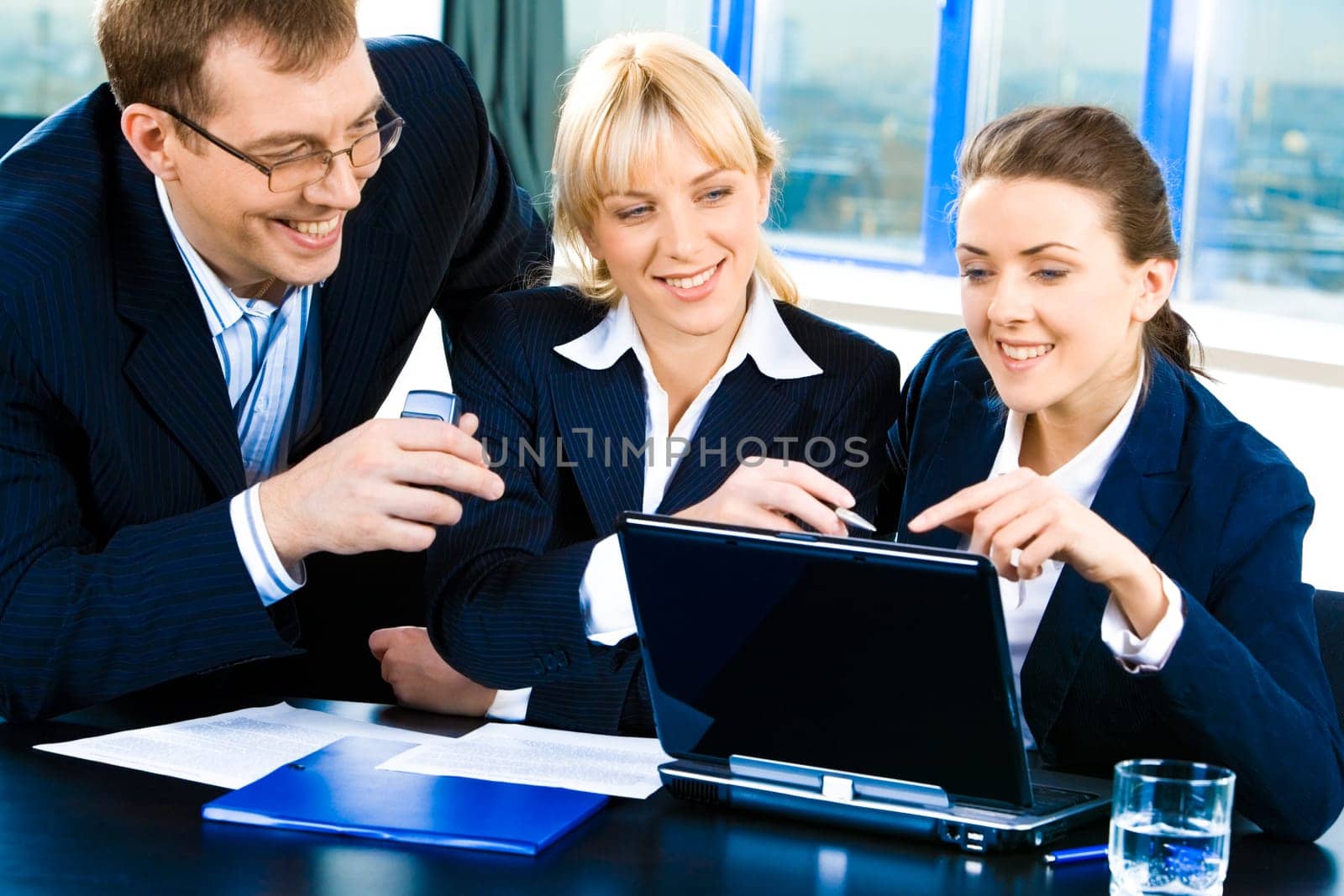 Team of three confident people gathered together for discussing a business-plan