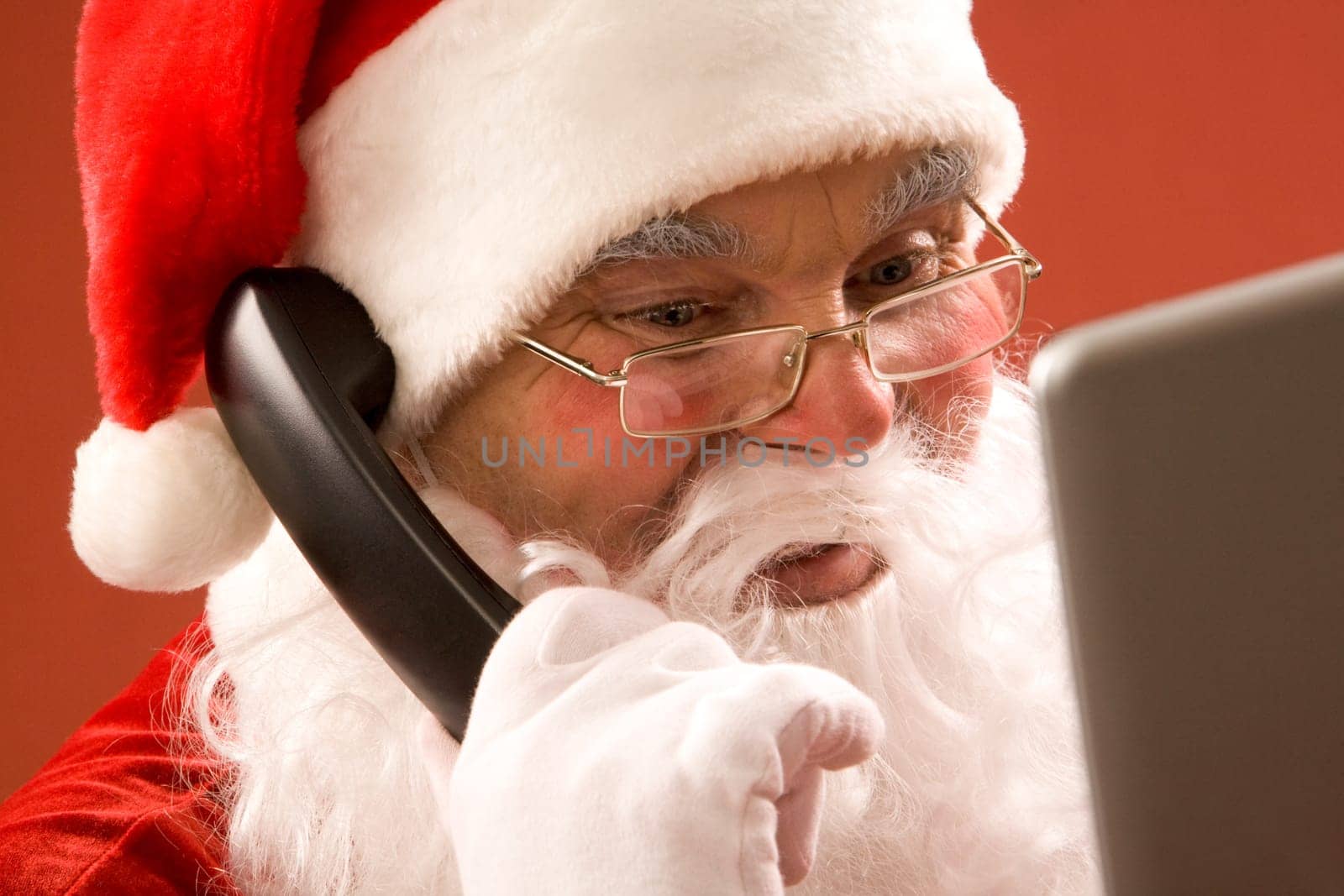 Photo of Santa Claus calling by phone and smiling