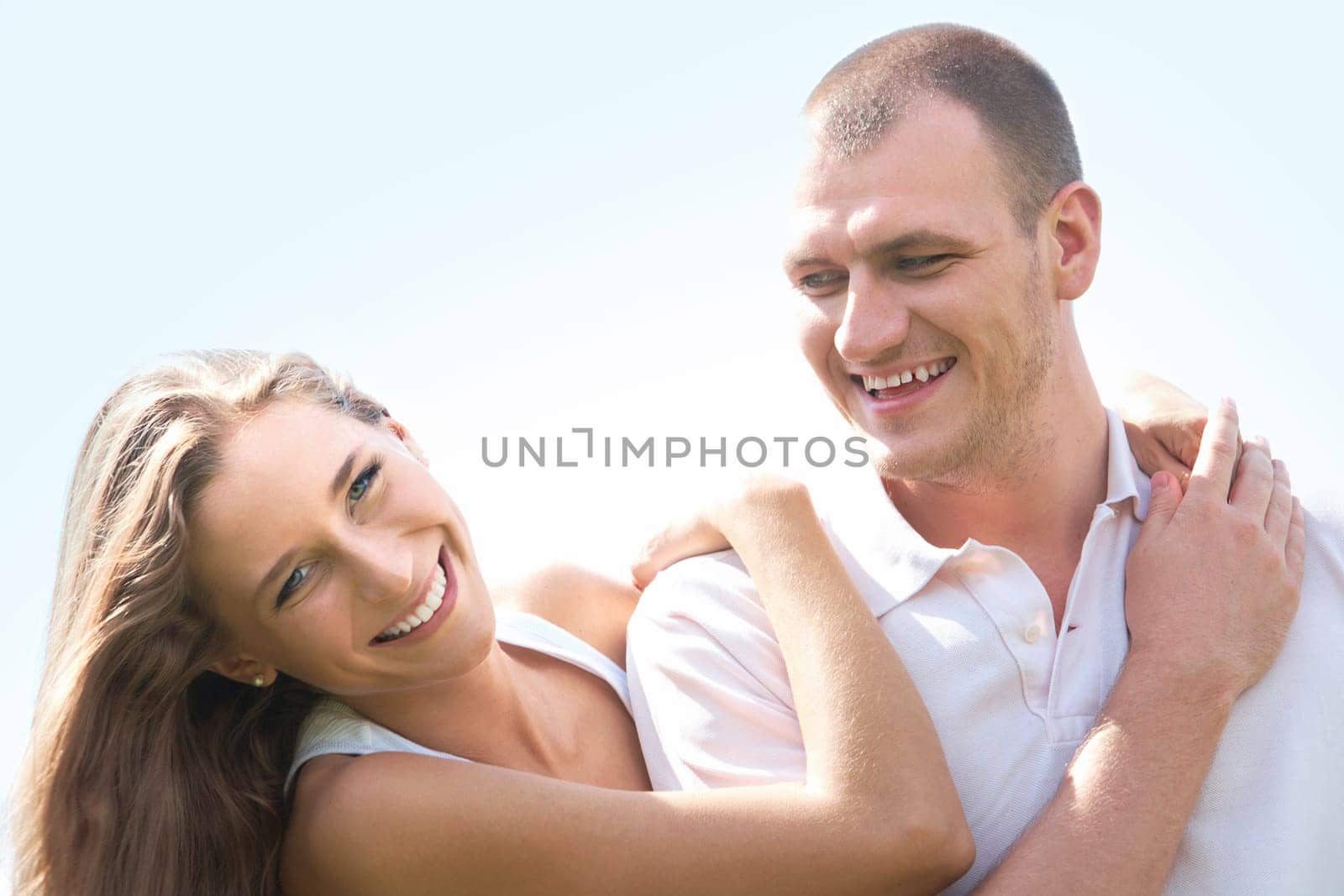 Portrait of happy girl hugging handsome man outside
