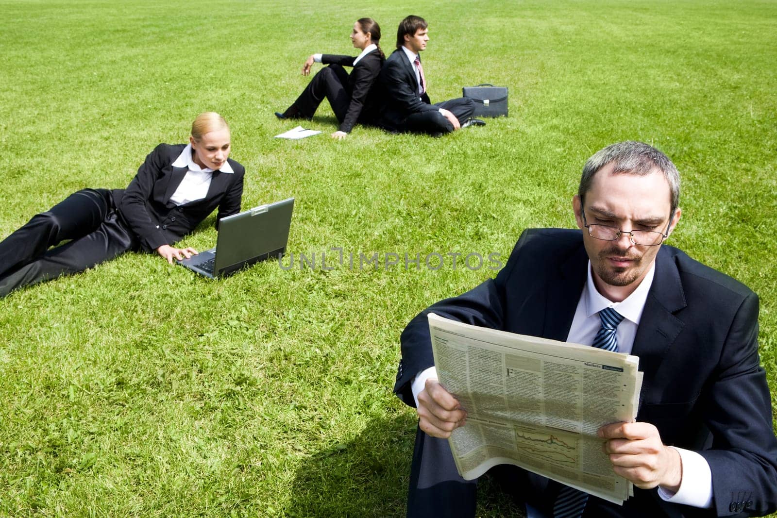 Photo of business group doing something on the grass