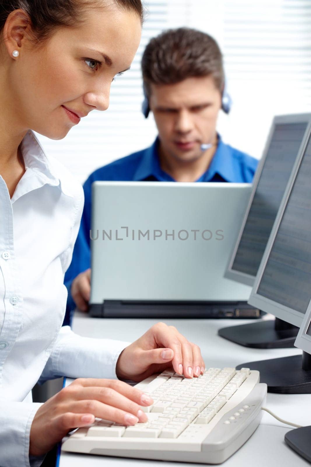Image of secretary doing computer work on the background of telephone operator