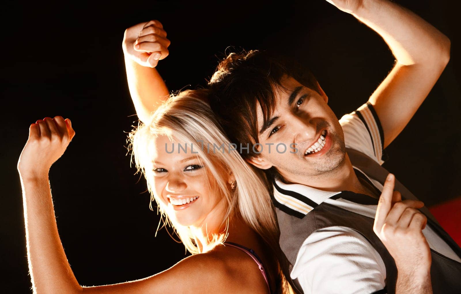 Positive couple looking at camera with smiles during disco