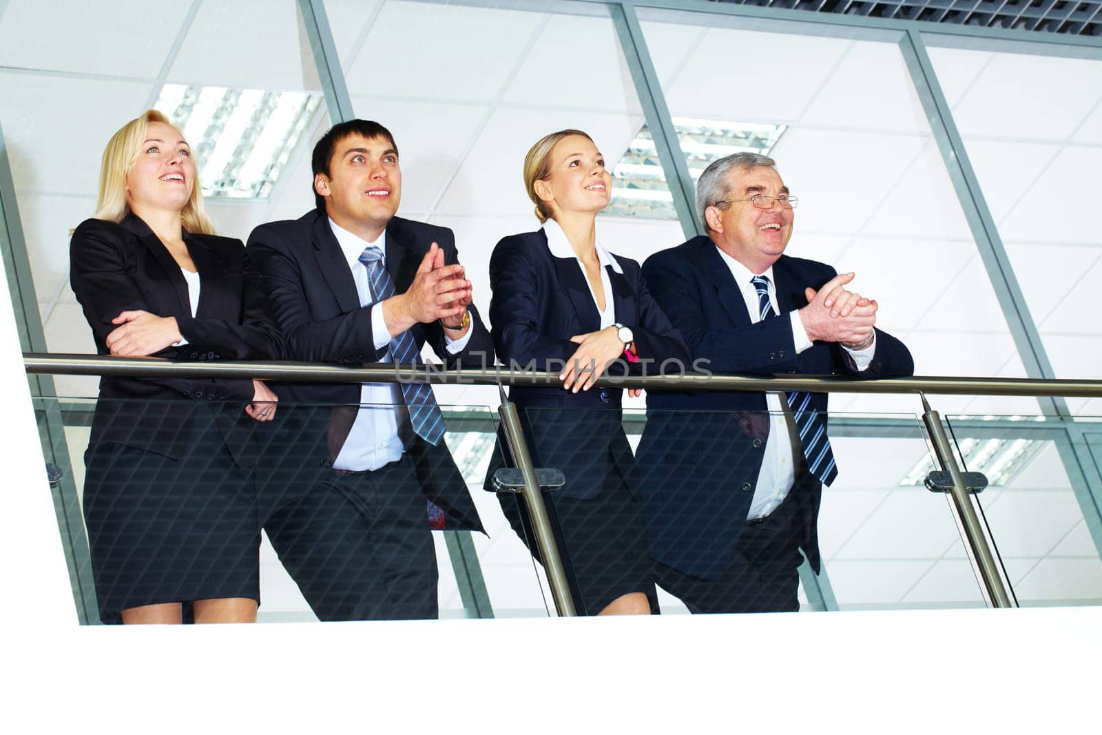 Group of businesspeople and their senior boss standing by banisters