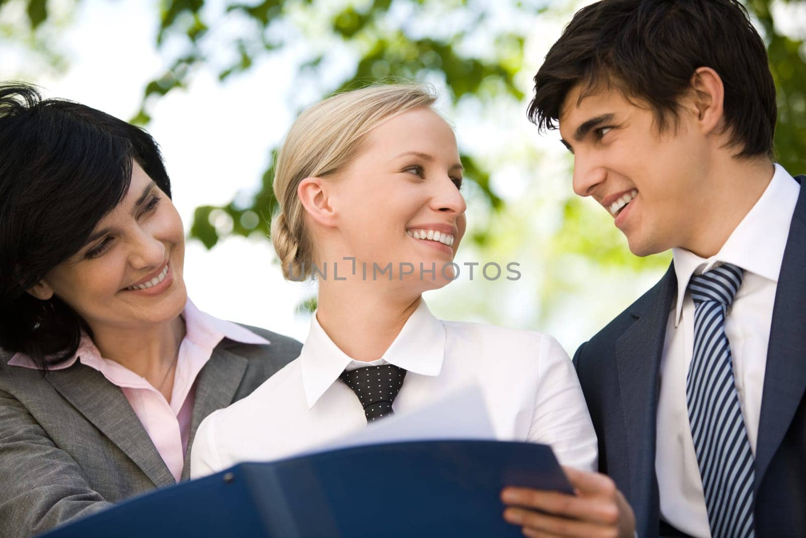 Portrait of happy people discussing new working plan outside at summer